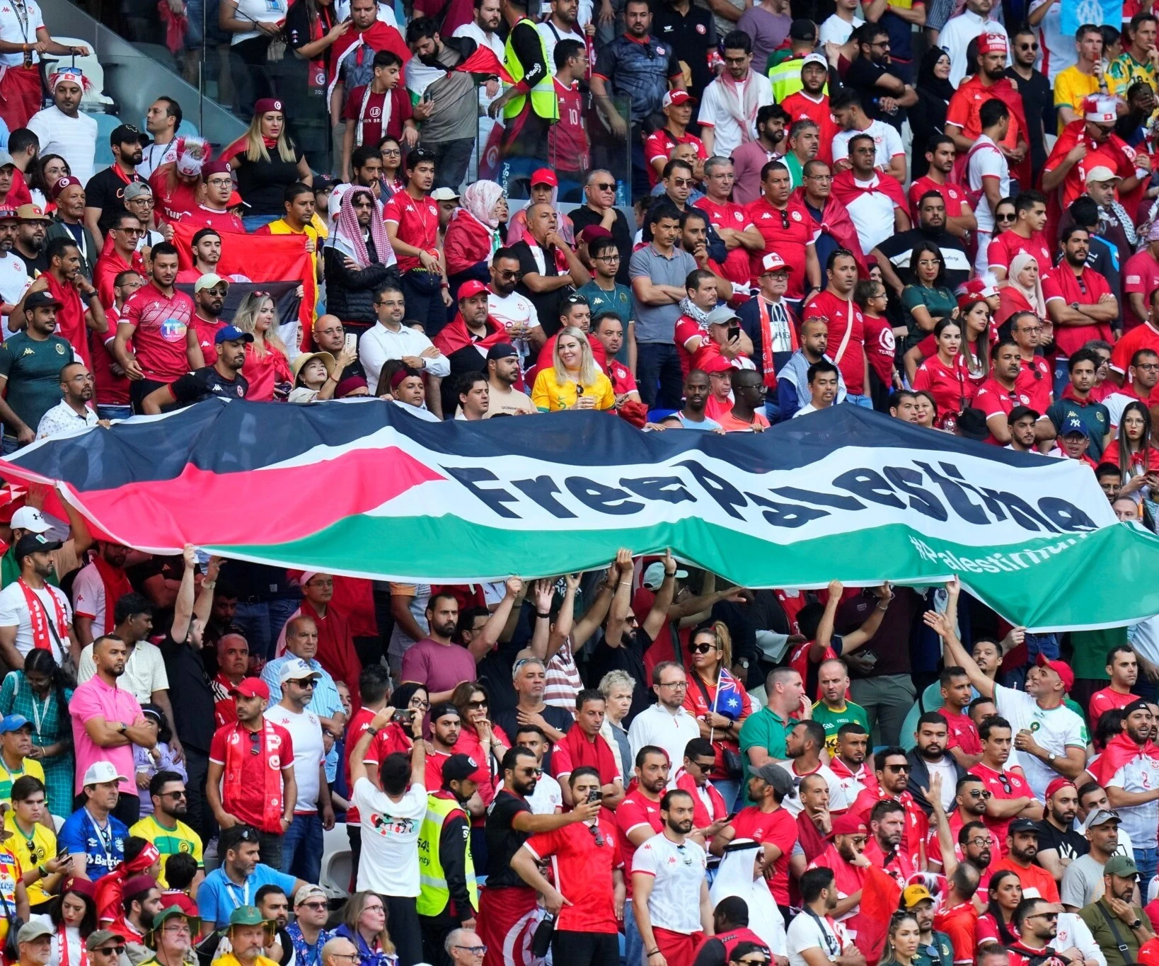 Supporters of Tunisia hold a flag of Palestine reading "Free Palestine" during the World Cup match between Tunisia and Australia in Al Wakrah, Qatar, November 26, 2022 (AP Photo) Supporters of Tunisia hold a flag of Palestine reading "Free Palestine" during the World Cup match between Tunisia and Australia in Al Wakrah, Qatar, November 26, 2022 (AP Photo)
