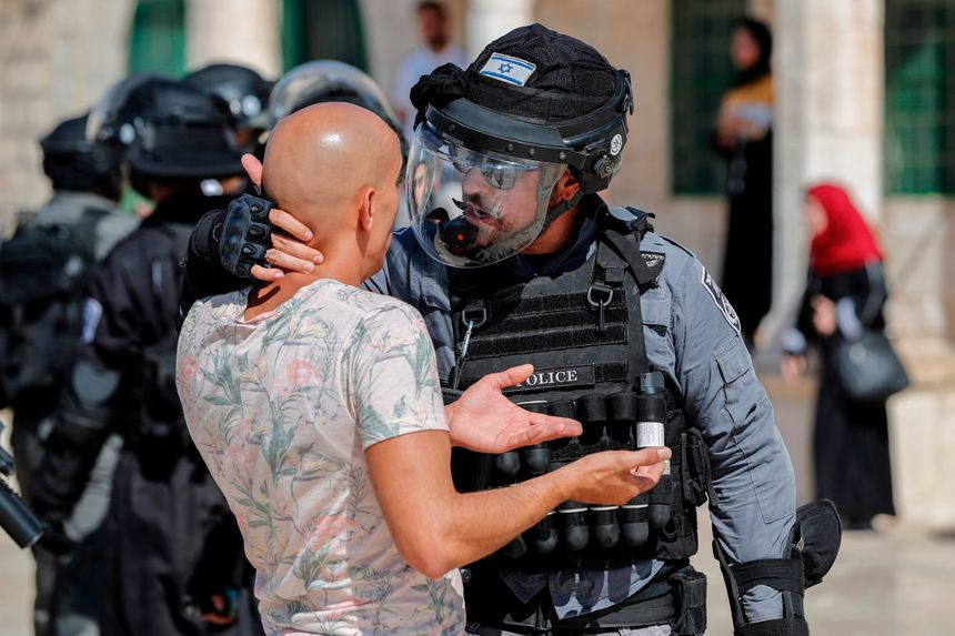 An Israeli occupation soldier physically abusing a Palestinian citizen near Al-Aqsa Mosque (Credit: Getty Images)