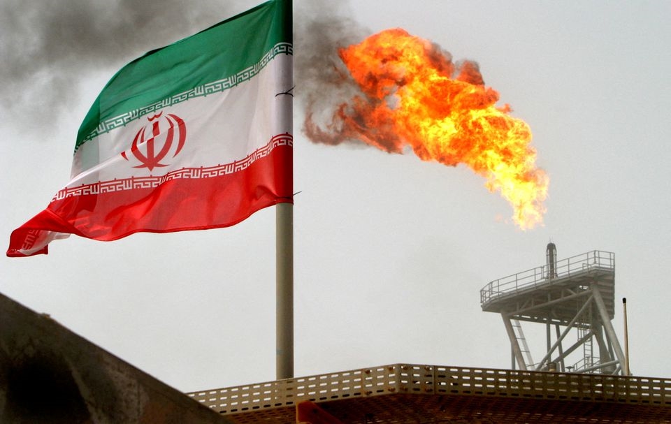 A gas flare on an oil production platform alongside an Iranian flag in the Gulf (Reuters)
