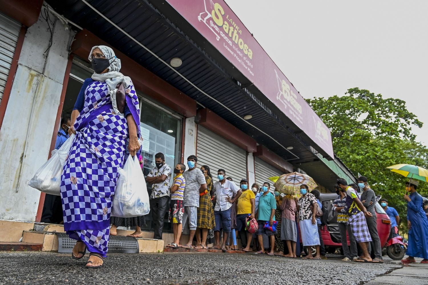 A woman carrying food bags from a state-run supermarket, September 3 2021(AFP/Getty)