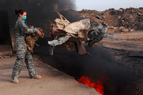 A US service member disposing of uniforms in a burn pit