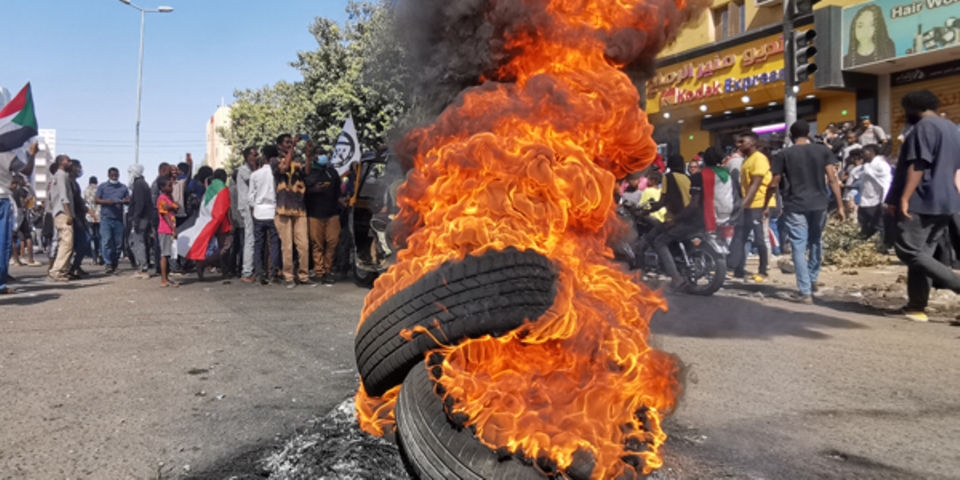 Sudanese protesters rallying against the military, walk past tyres set ablaze by fellow demonstrators in the capital Khartoum, on January 6, 2022. PHOTO/ AFP