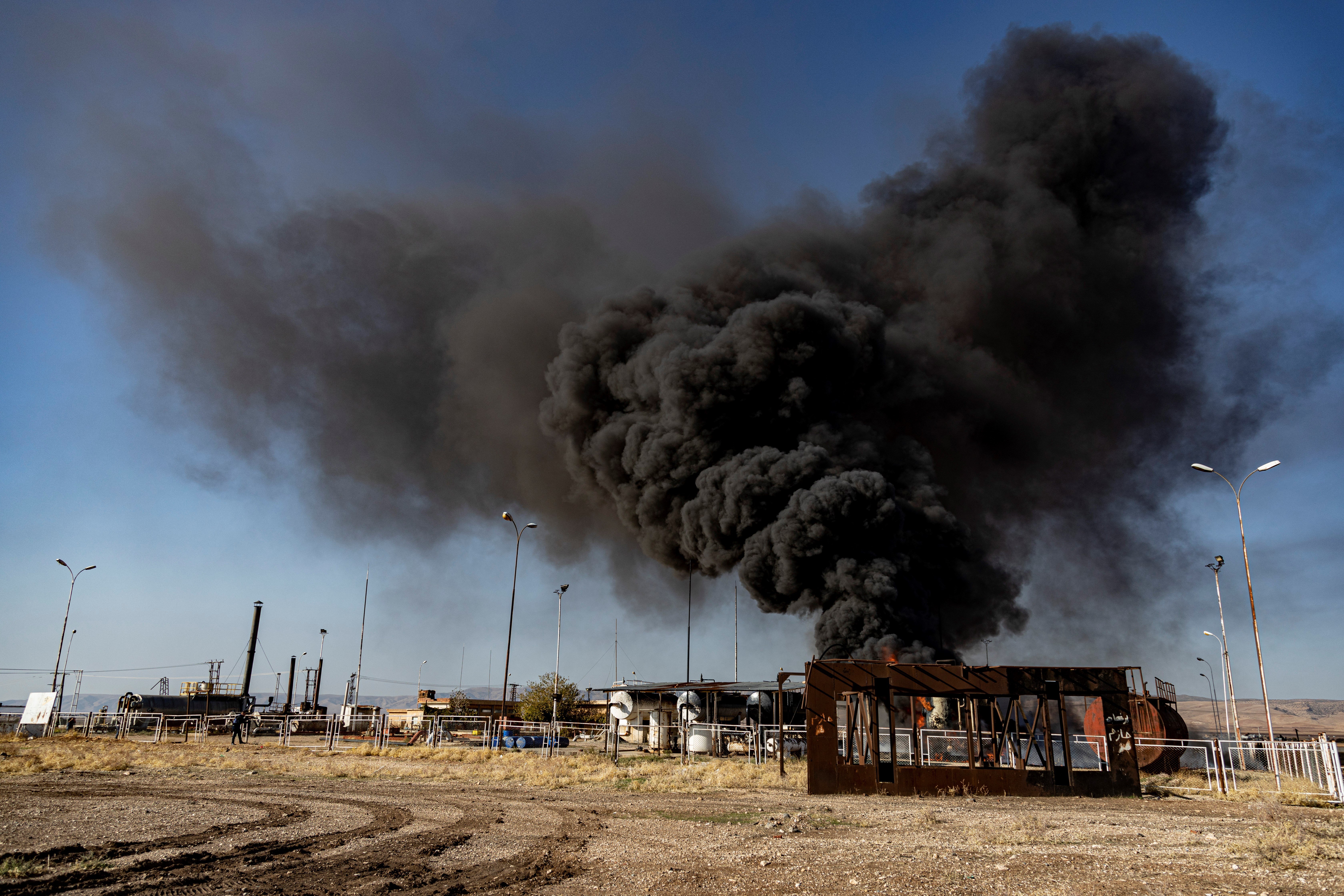 A smoke rises from an oil depot struck by Turkish air force near the town of Qamishli, Syria, Wednesday, Nov. 23, 2022 (AP Photo/Baderkhan Ahmad)
