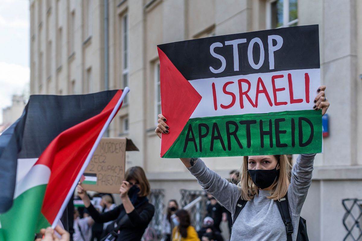 A protester holds up a sign in support of Palestine (AFP)