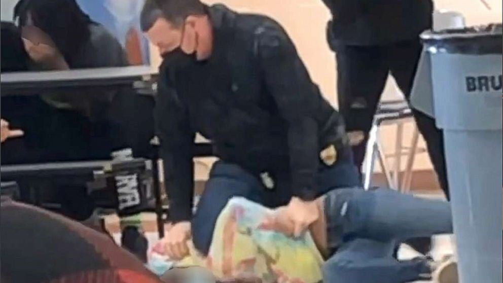 An off-duty police officer is shown kneeling on the 12-year-old student's neck on March 4, 202