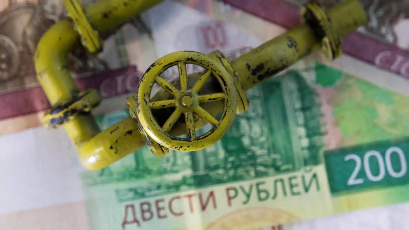 A model of a natural gas pipeline is placed on ruble banknotes (Reuters)