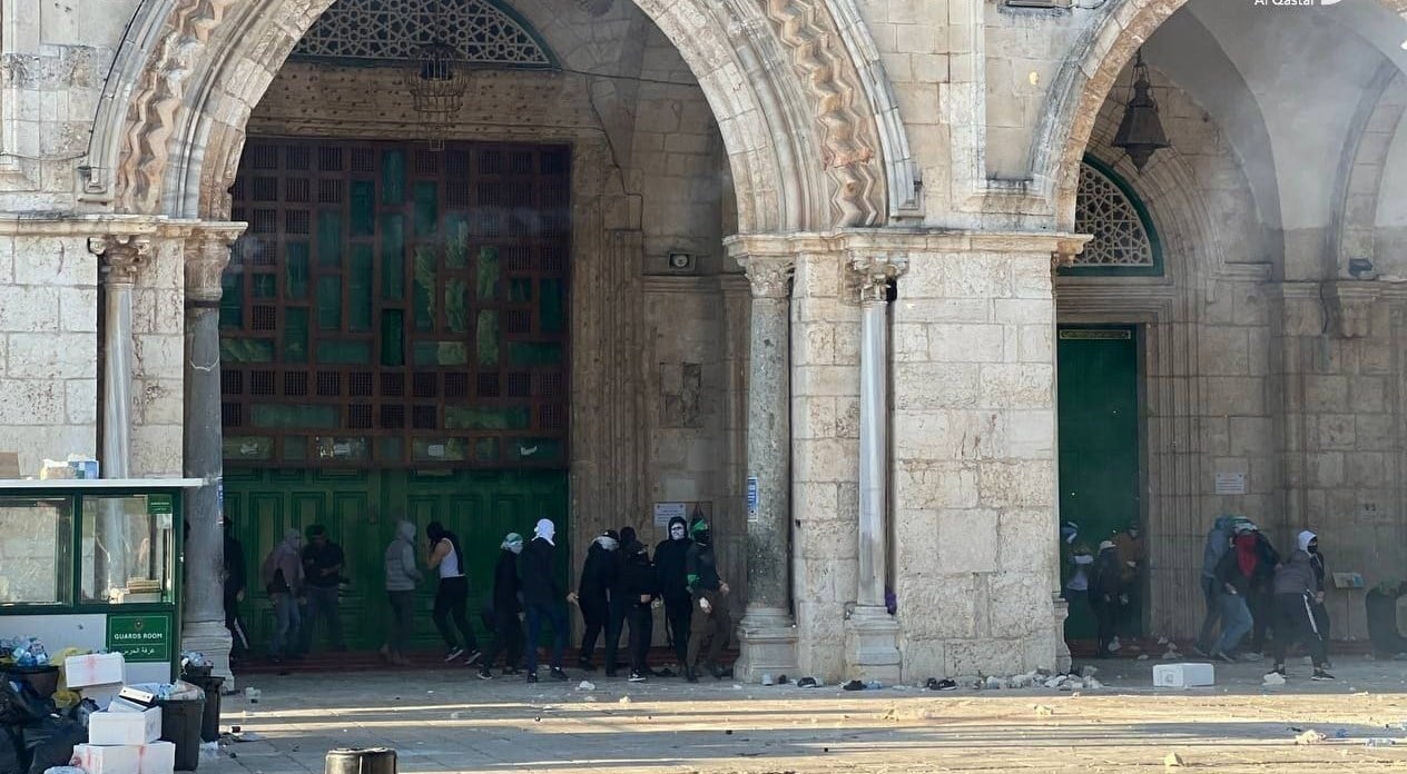 Palestinian civilians confronting occupation forces in Al-Aqsa Mosque