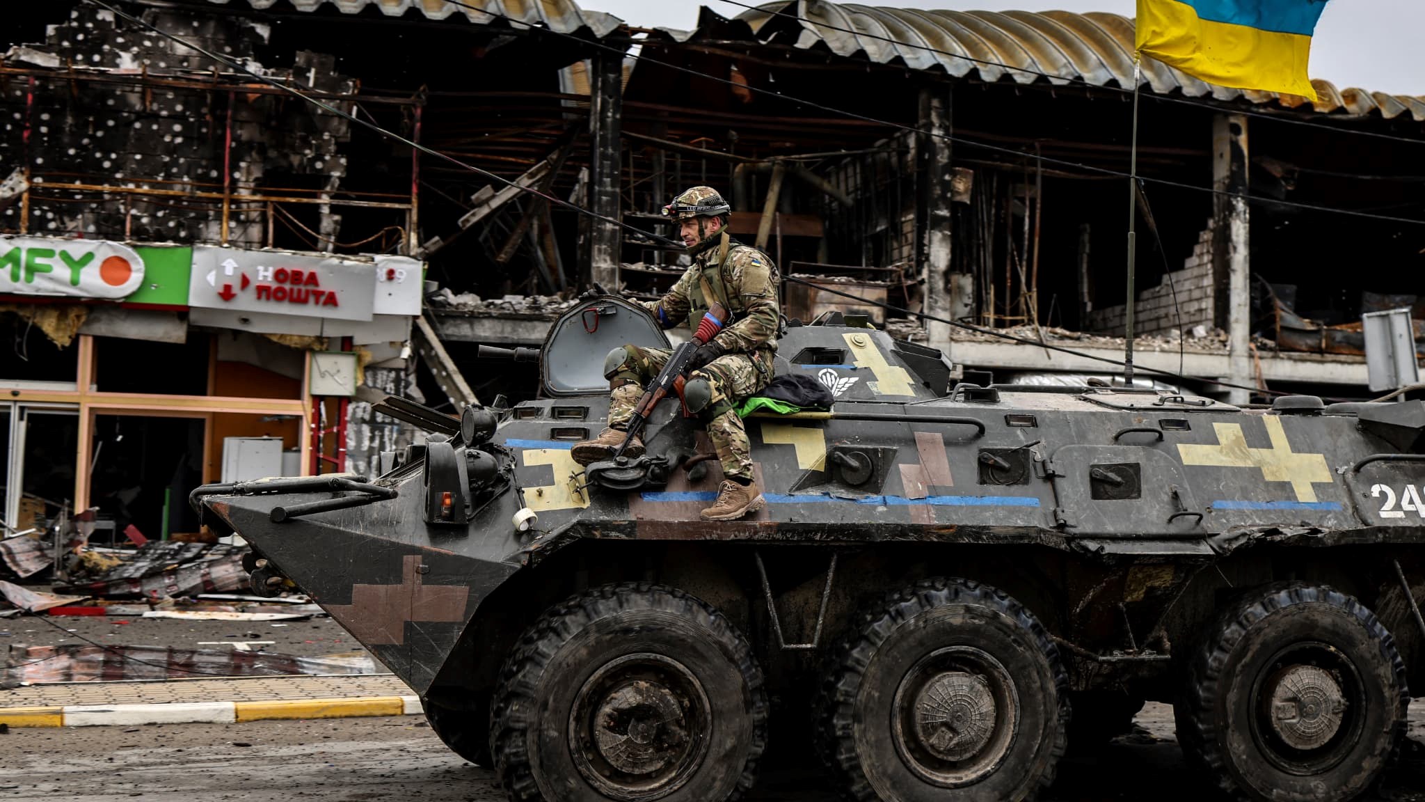 A Ukrainian soldier mounting an armored vehicle in Bucha, Ukraine