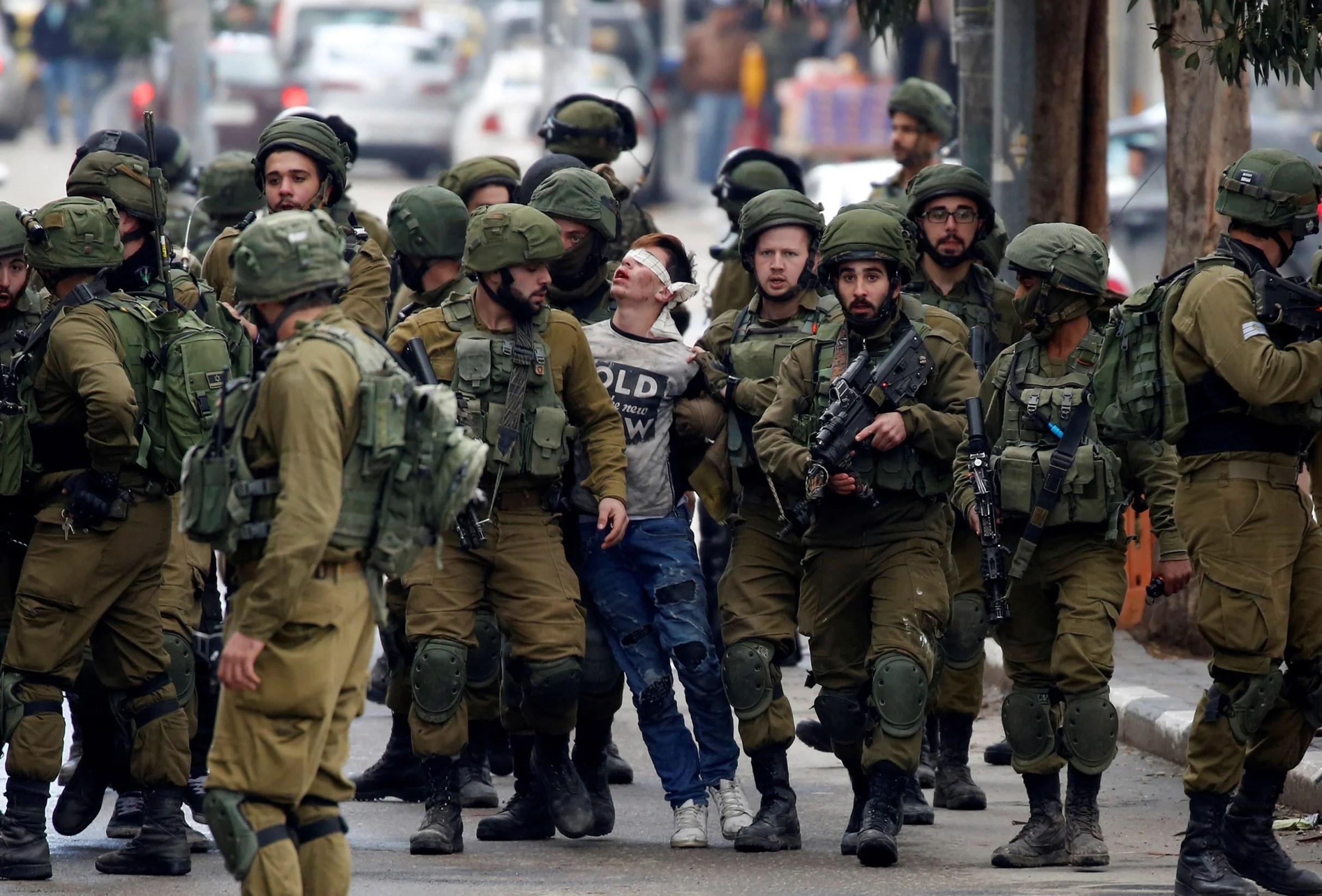 The Israeli occupation forces detain Palestinian Fawzi Al-Junidi, 14, in Al-Khalil, the occupied West Bank 