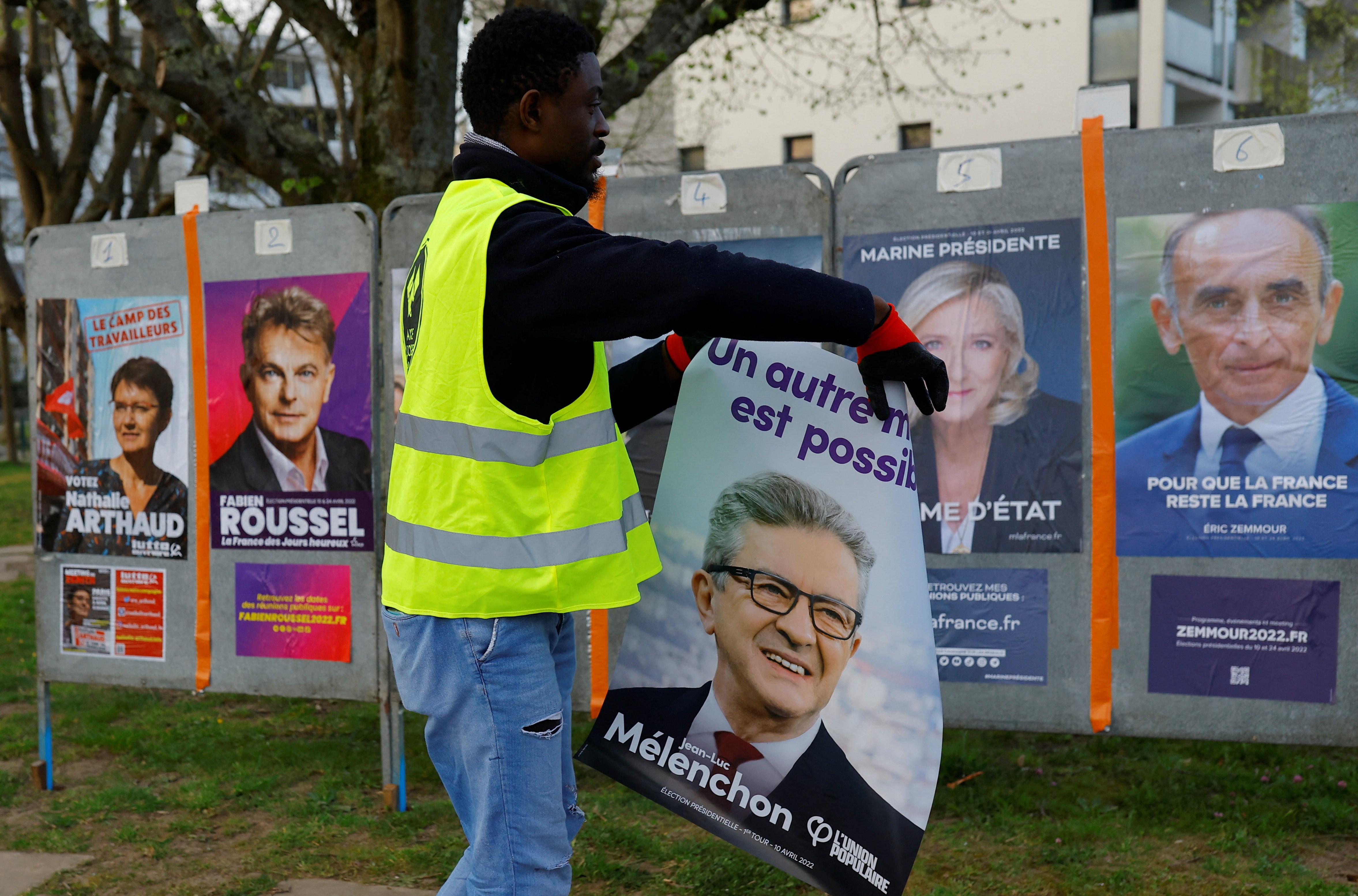France Affichage Plus workers paste official campaign posters of French Presidential election candidates on electoral panels in Saint-Herblain near Nantes, France, March 28, 2022 (Reuters)