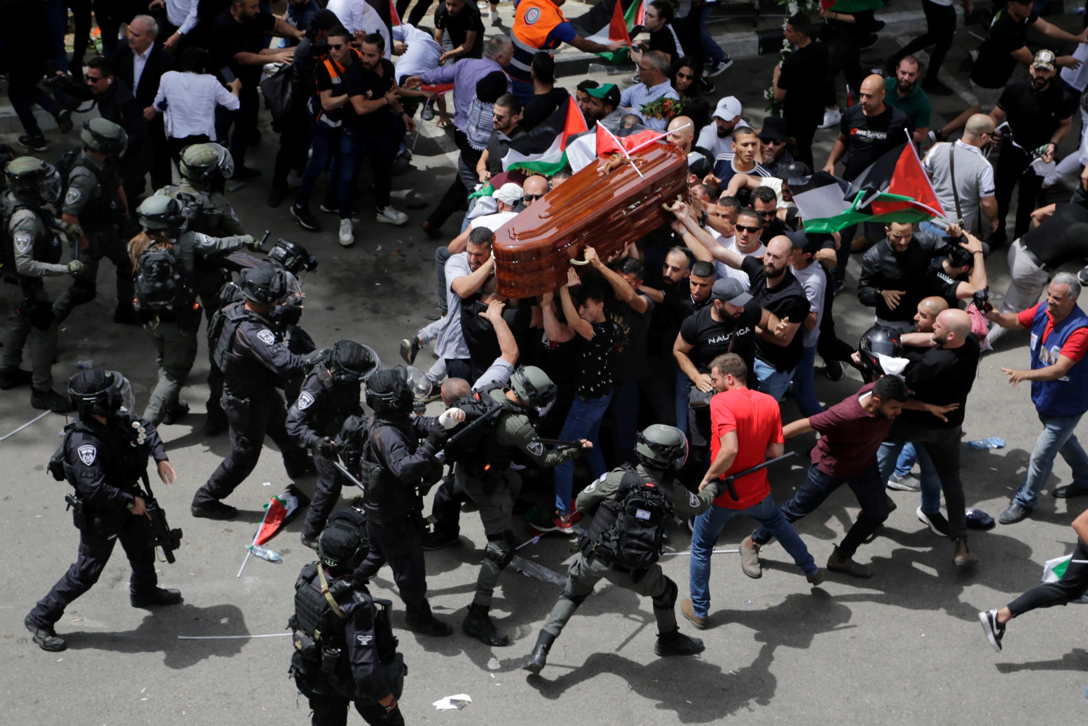 Israeli occupation police officers attacking mourners at the funeral of Shireen Abu Akleh, a Palestinian journalist for Al Jazeera who the IOF killed this week in the occupied West Bank, occupied Palestine