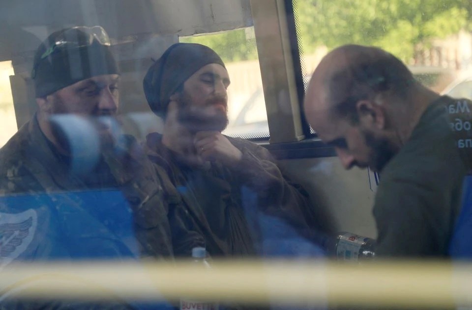 Ukrainian fighters who have surrendered after weeks of being sieged at the Azovstal steel plant are seen inside a bus, Mariupol May 17, 2022 (Reuters)