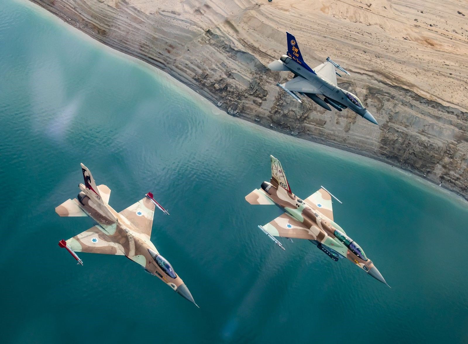 Two Israeli and one American F-16 fighter jets fly alongside one another during a joint exercise in southern occupied Palestine in January 2022