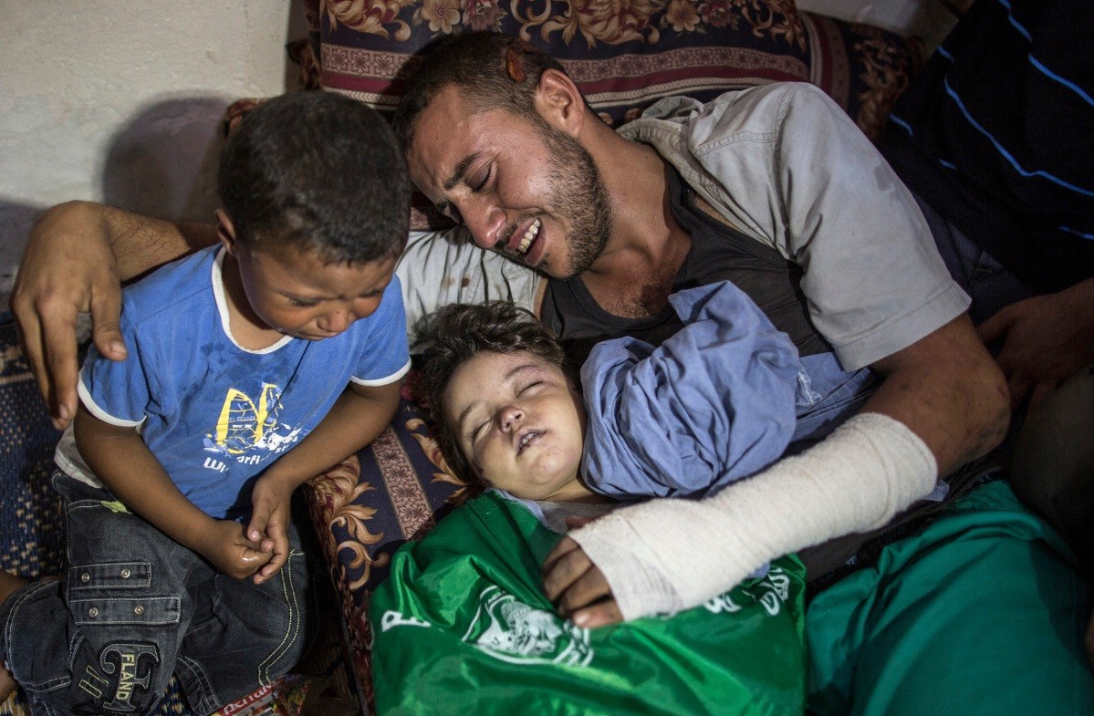 Yehya Hassan and his son crying over the body of two-year-old Rahaf, who was killed in an Israeli airstrike, October 2015 (Time)