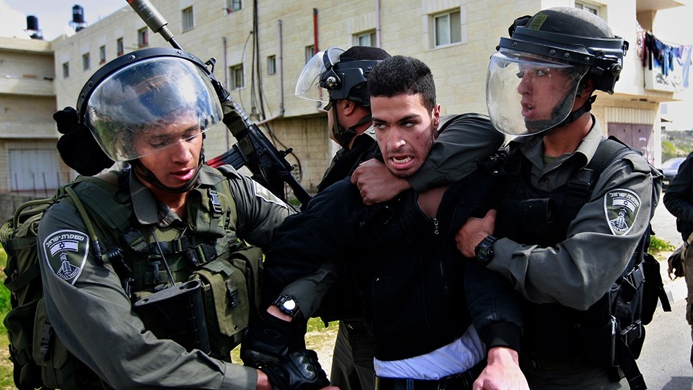 Israeli occupation soldiers detaining a Palestinian man in the West Bank, occupied Palestine