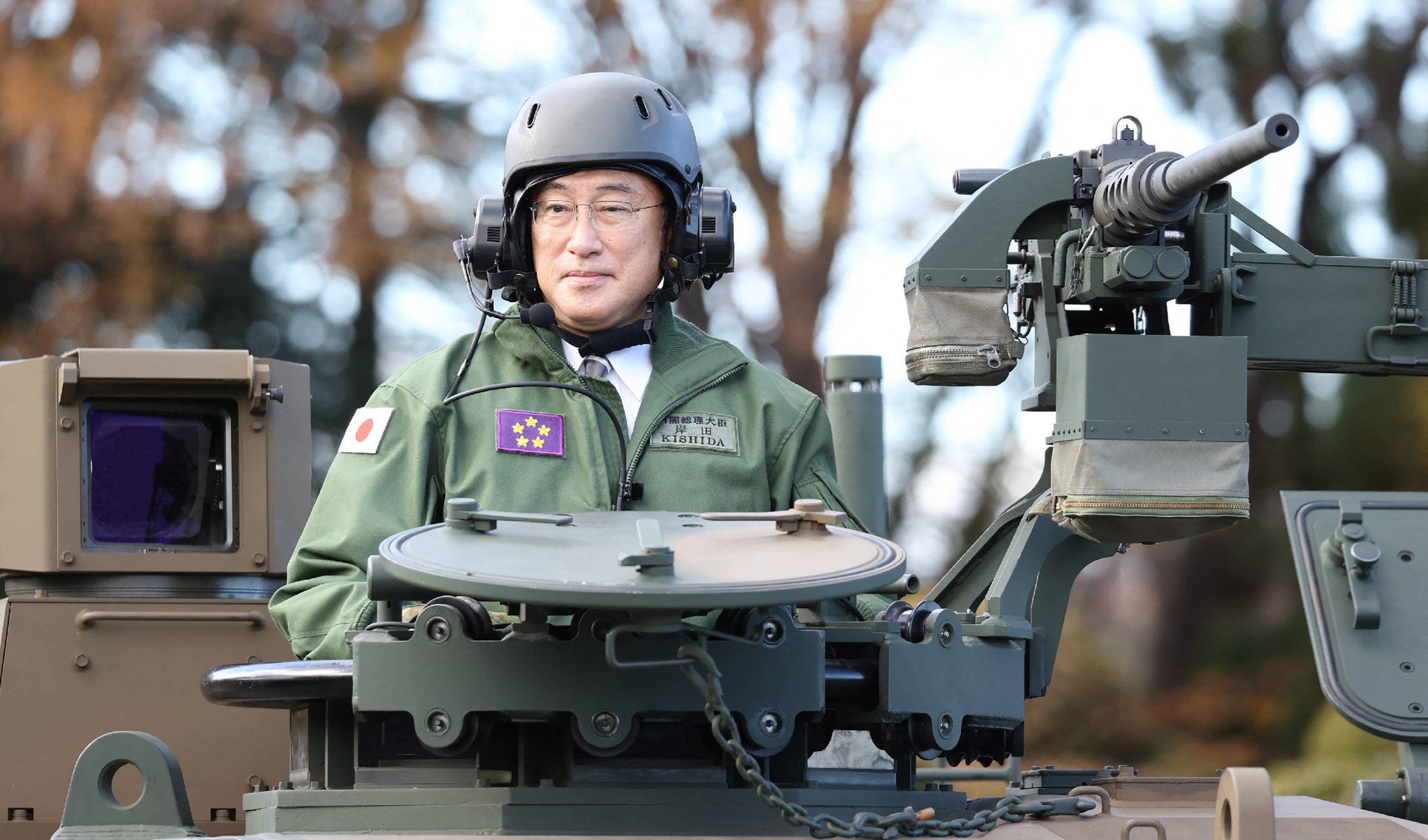 Japanese Prime Minister Fumio Kishida rides on a Japan Ground Self-Defense Force tank