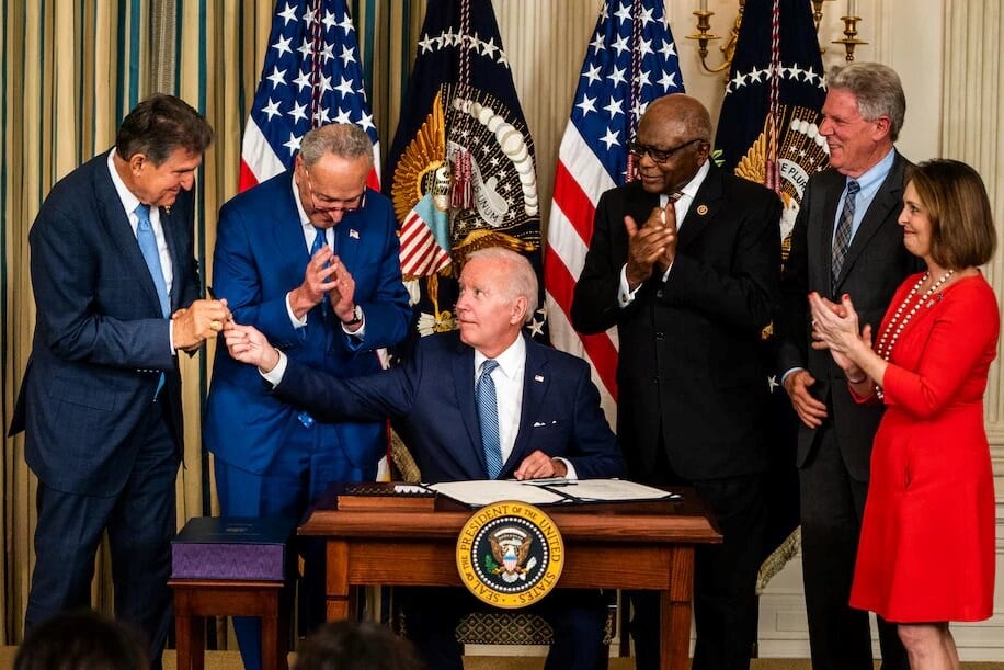 President Biden hands Sen. Joe Manchin III (D-W.Va) the pen used to sign into law the Inflation Reduction Act. (The Washington Post)