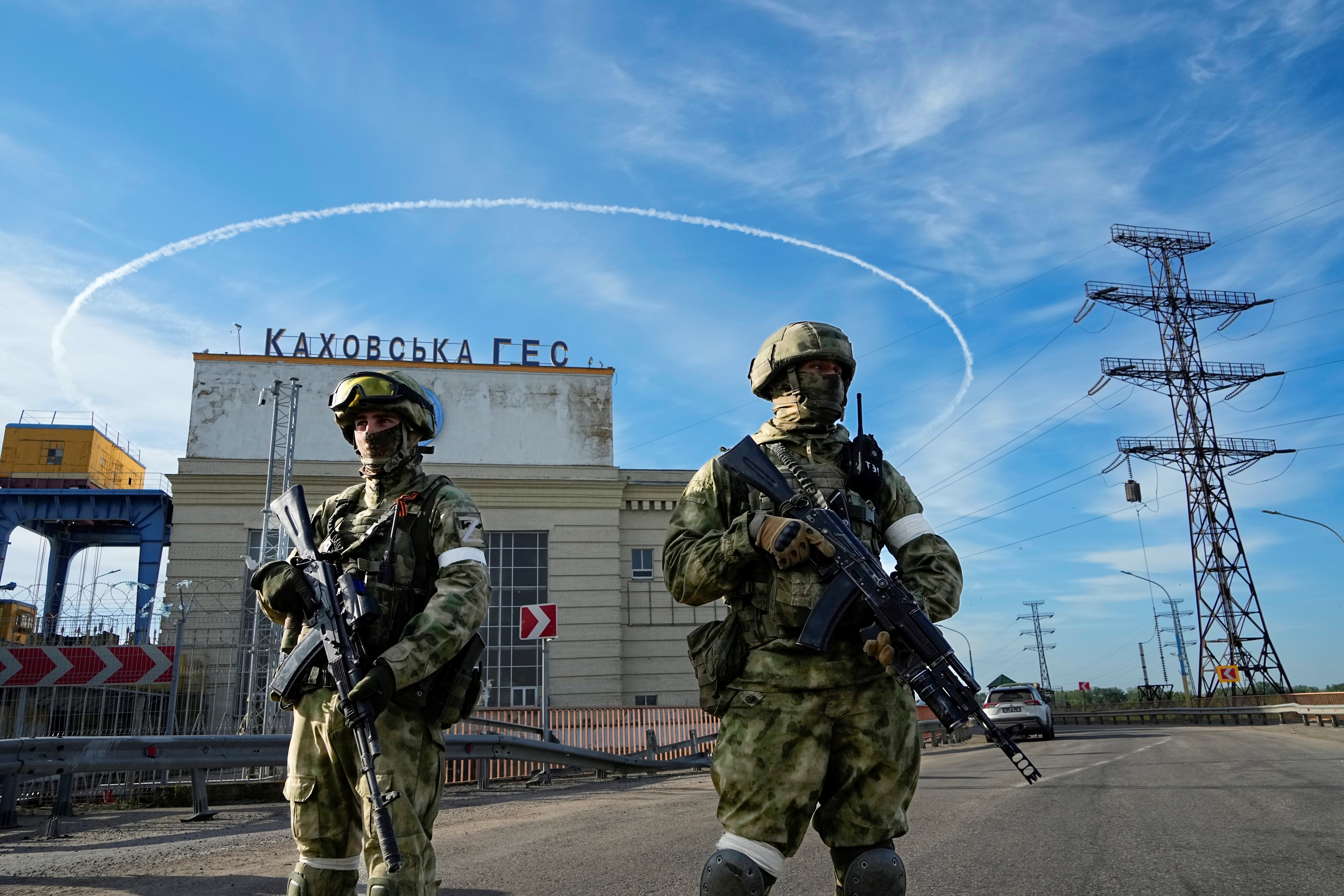 Russian troops guard an entrance of the Kakhovka Hydroelectric Station, a run-of-the-river power plant on the Dnieper River in Kherson region, southern Ukraine, Friday, May 20, 2022, during a trip organized by the Russian MoD