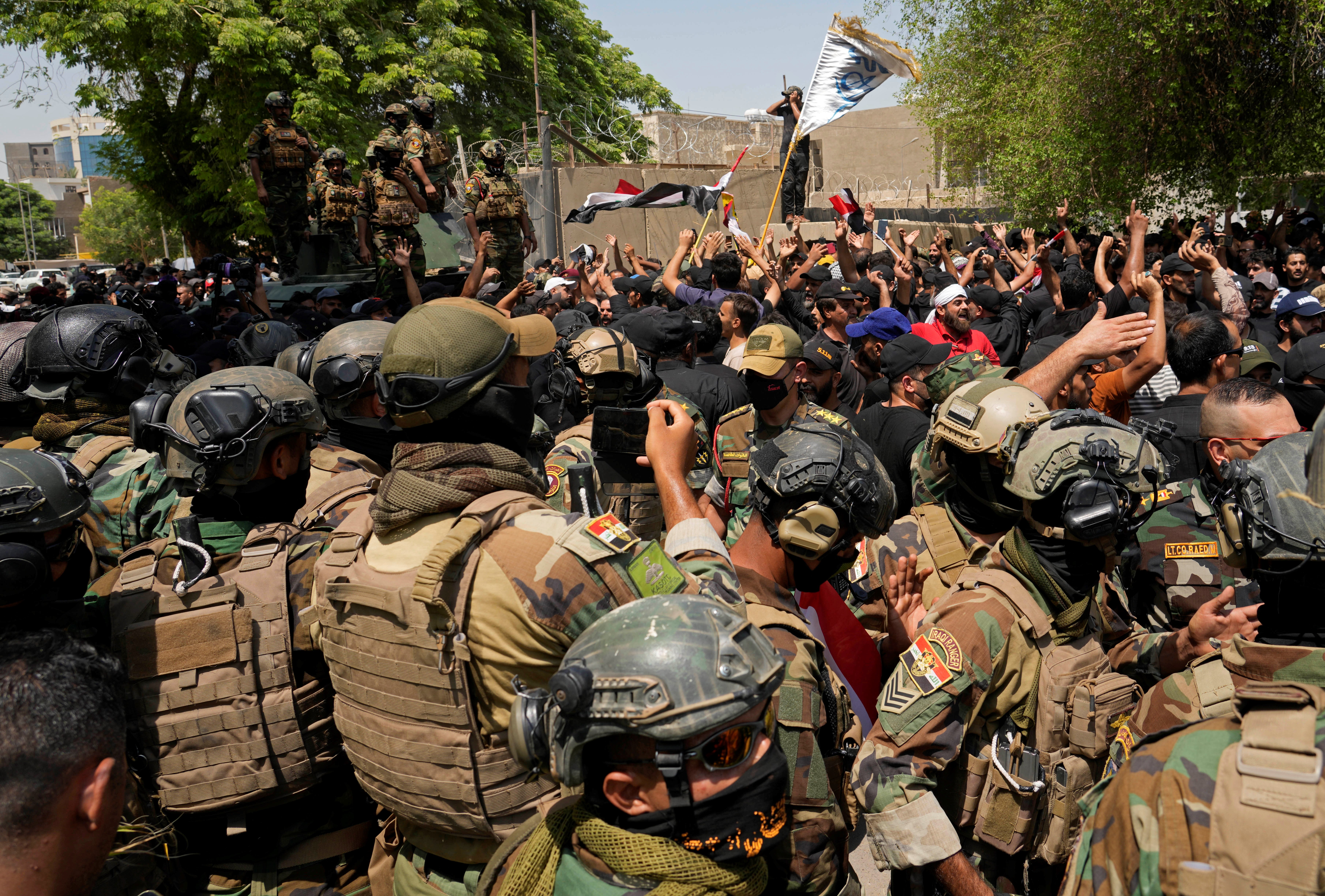 Soldiers standby as supporters of Muqtada al-Sadr protest in front the Supreme Judicial Council, in Baghdad, Iraq, Tuesday, Aug. 23, 2022 (AP Photo/Hadi Mizban)