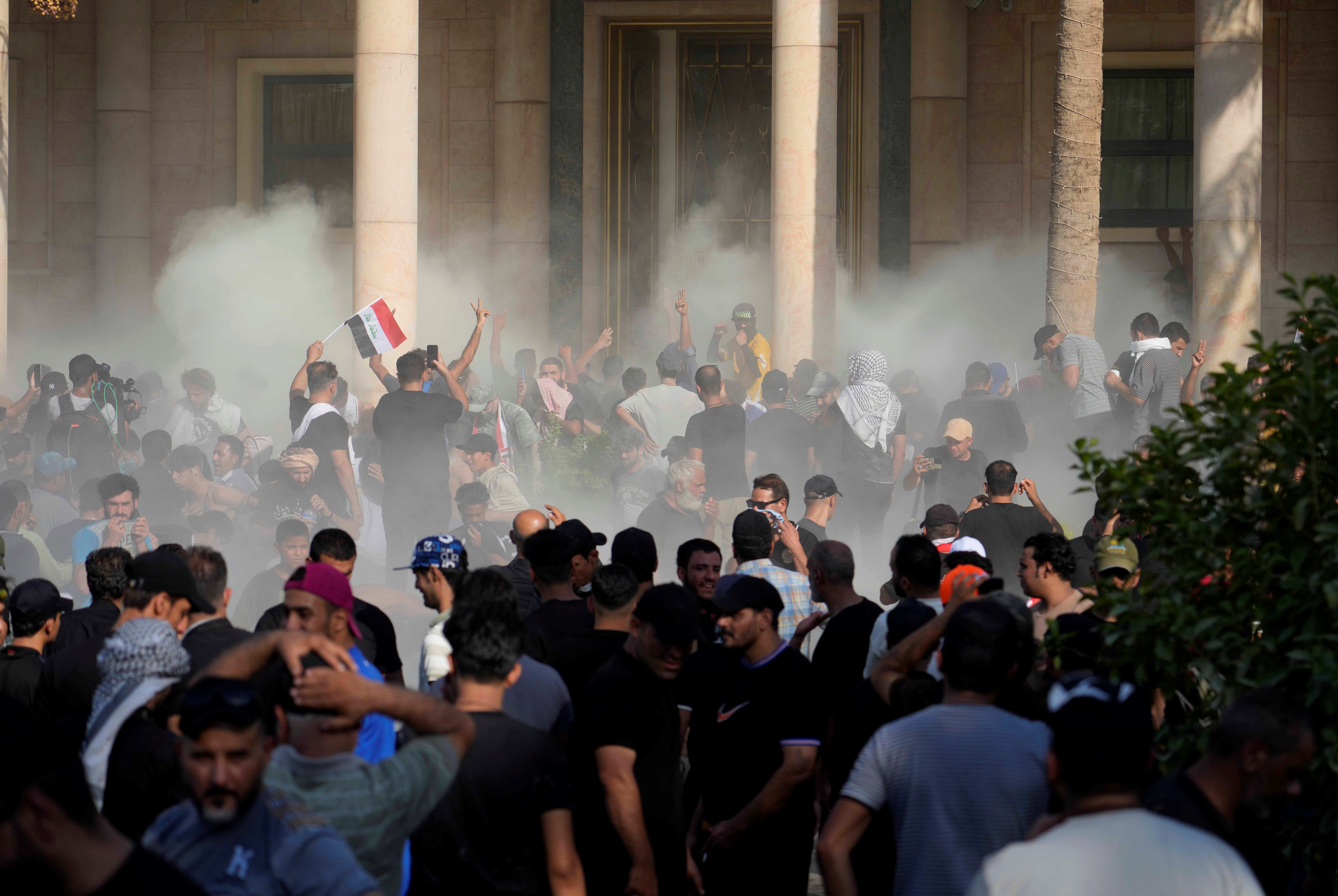 Iraqi security forces fire tear gas on the followers of Shiite cleric Muqtada al-Sadr inside the government Palace, Baghdad, Iraq, Monday, Aug. 29, 2022 (AP Photo/Hadi Mizban)