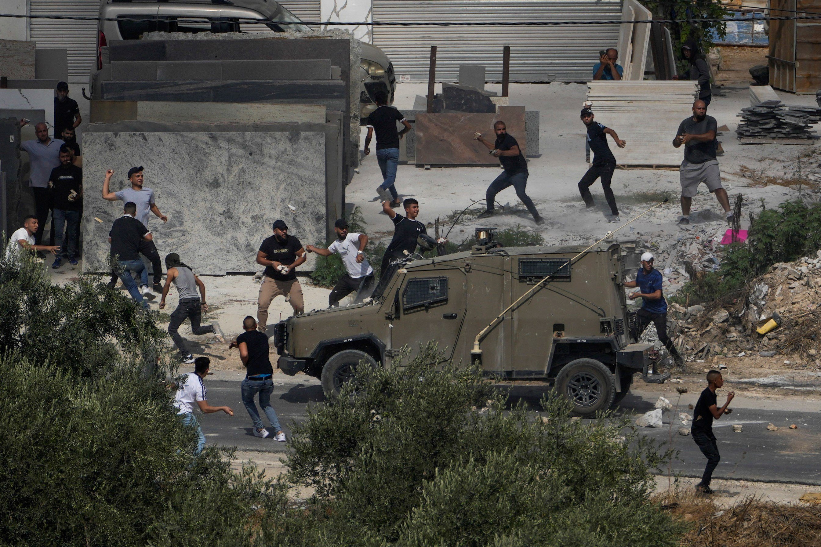 Palestinians hurl rocks at Israeli occupation vehicles during an Israeli raid in the West Bank village of Rujib, Palestine Tuesday, Aug. 30, 2022 (AP Photo/Majdi Mohammed)