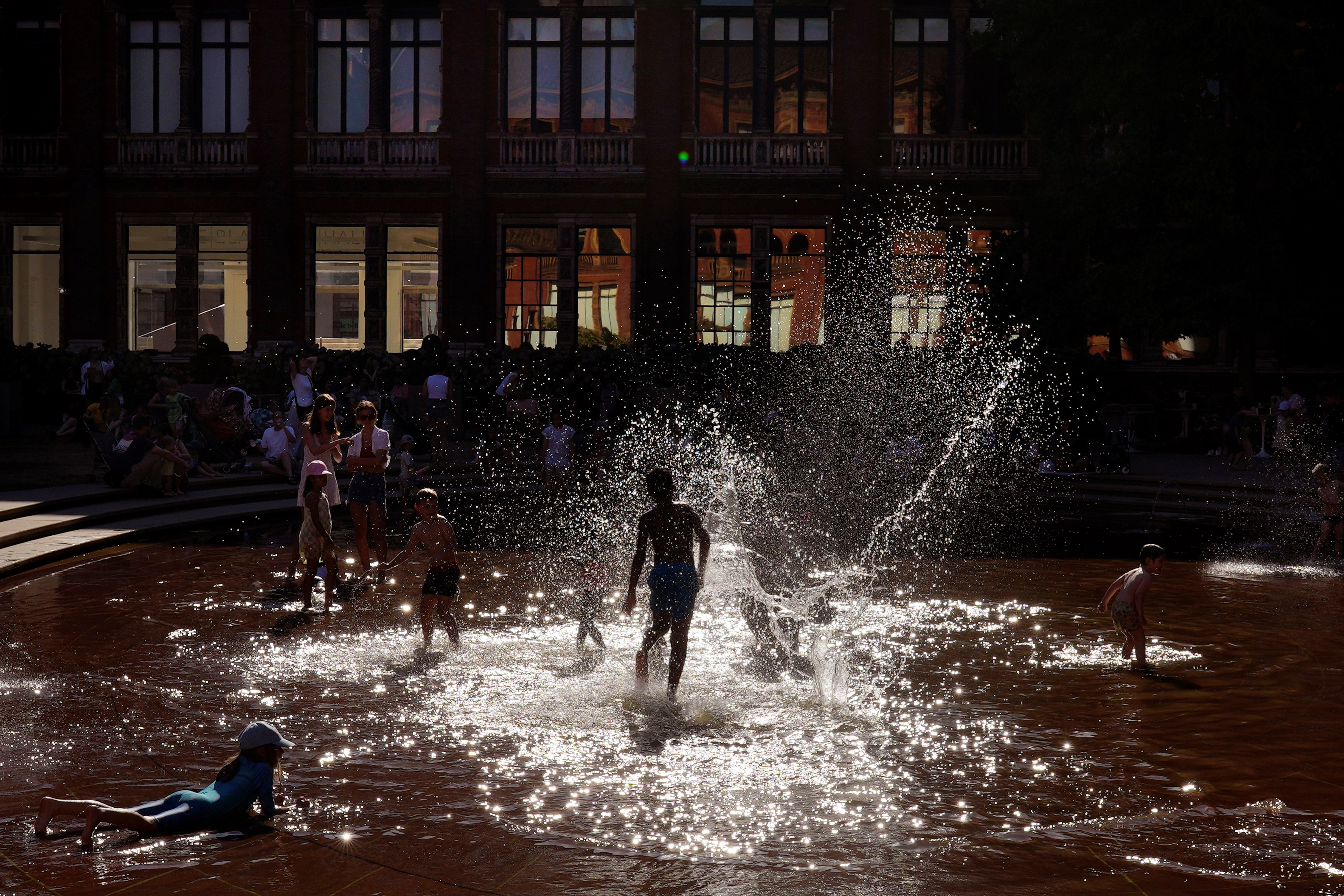 Children play in a fountain to beat the heat at the Victoria and Albert Museum in London, England, Friday, Aug. 12, 2022 (AP Photo/Manish Swarup)