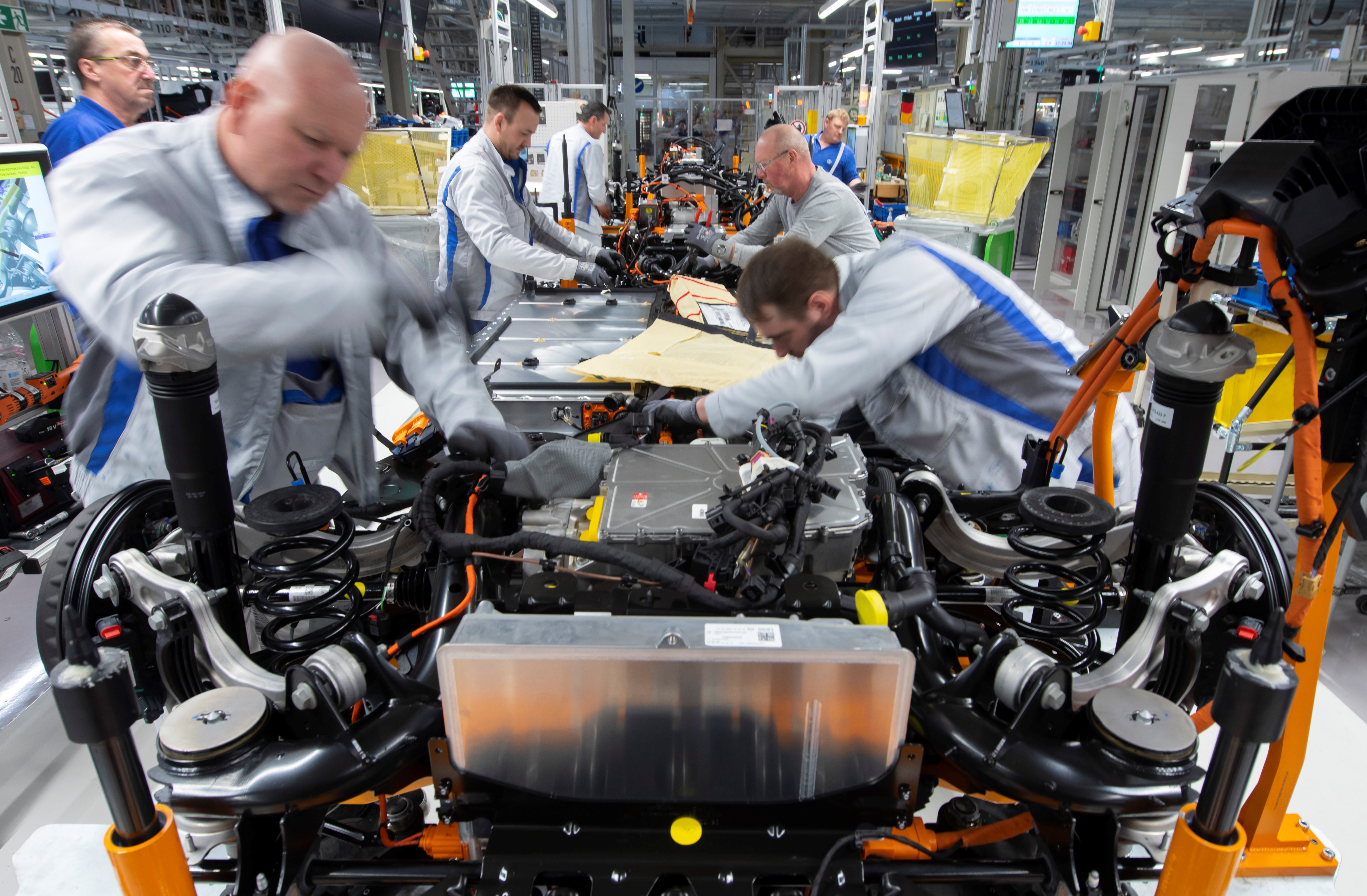 Workers complete an electric car ID.3 body at the assembly line during a press tour at the plant of the German manufacturer Volkswagen AG (VW) in Zwickau, Germany, Tuesday, Feb. 25. 2020 (AP Photo/Jens Meyer, file)