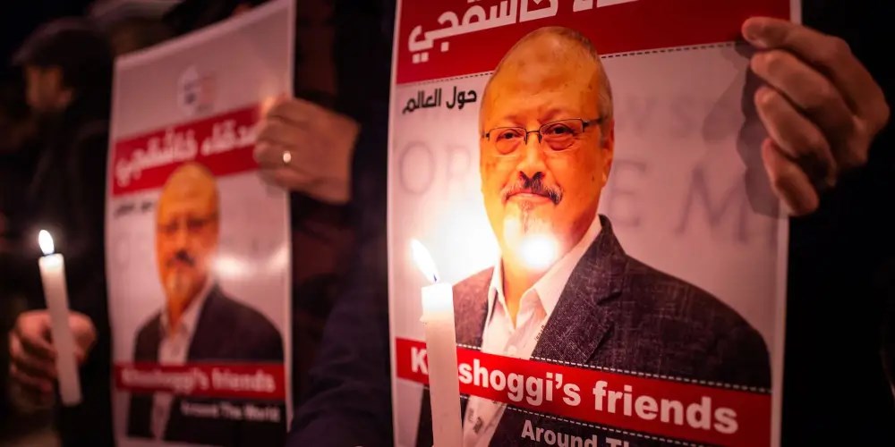 People hold posters picturing Saudi journalist Jamal Khashoggi and lightened candles during a gathering outside the Saudi Arabia consulate in Istanbul, on October 25, 2018. Yasin Akgul/Getty Images.