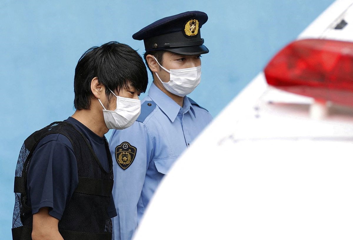 Tetsuya Yamagami is escorted by a police officer as he is taken to prosecutors, at Nara-nishi police station in Nara, western Japan, July 10, 2022 (Kyodo).