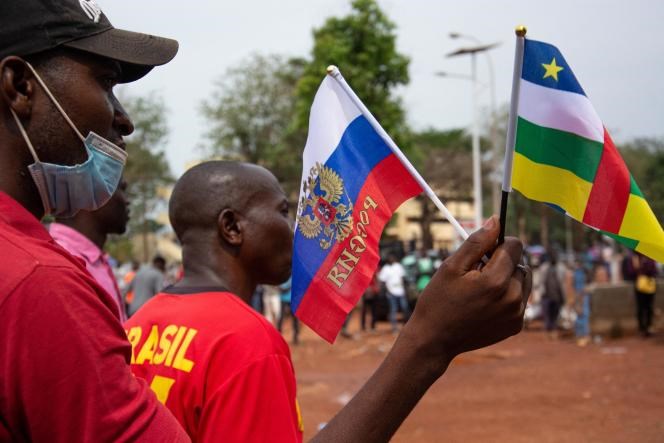 Two individuals holding the flags of Central African Republic and Russia during a demonstration in support of Russia, in Bangui, March 5, 2022 (AFP).