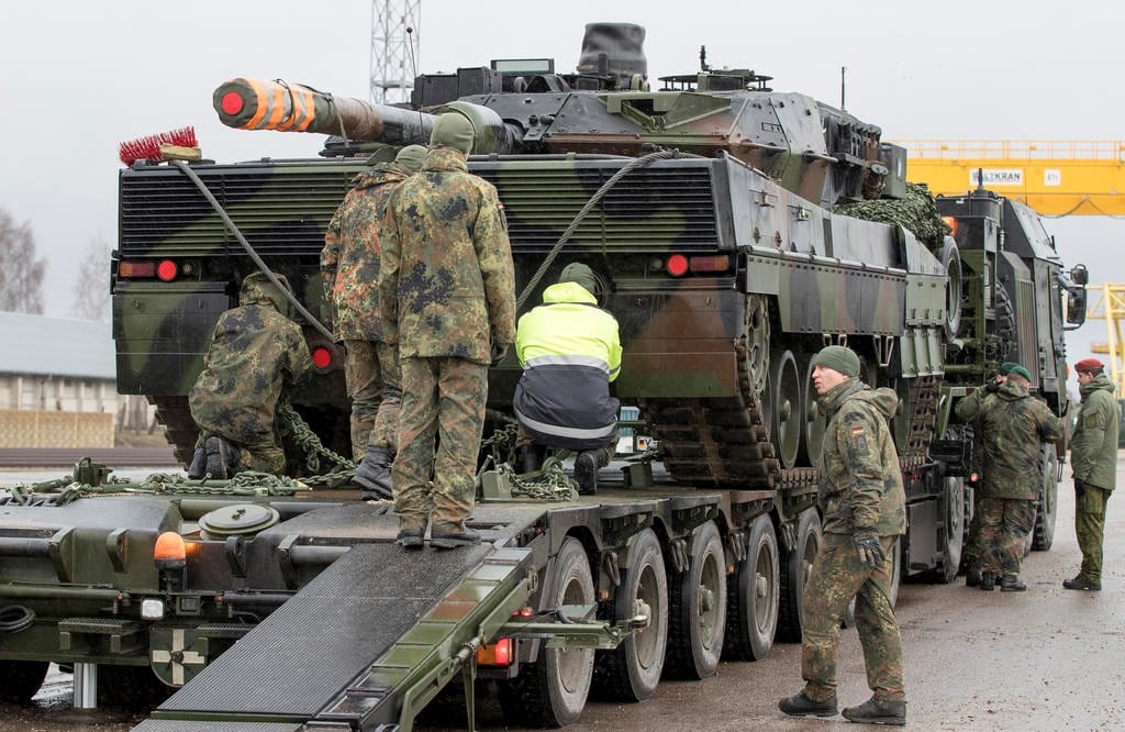 German army soldiers load a Leopard 2 tank onto a truck at the Sestokai railway station some 175 kms (109 miles) west of the capital Vilnius, Lithuania, Friday, Feb. 24, 2017 (AP Photo/Mindaugas Kulbis)