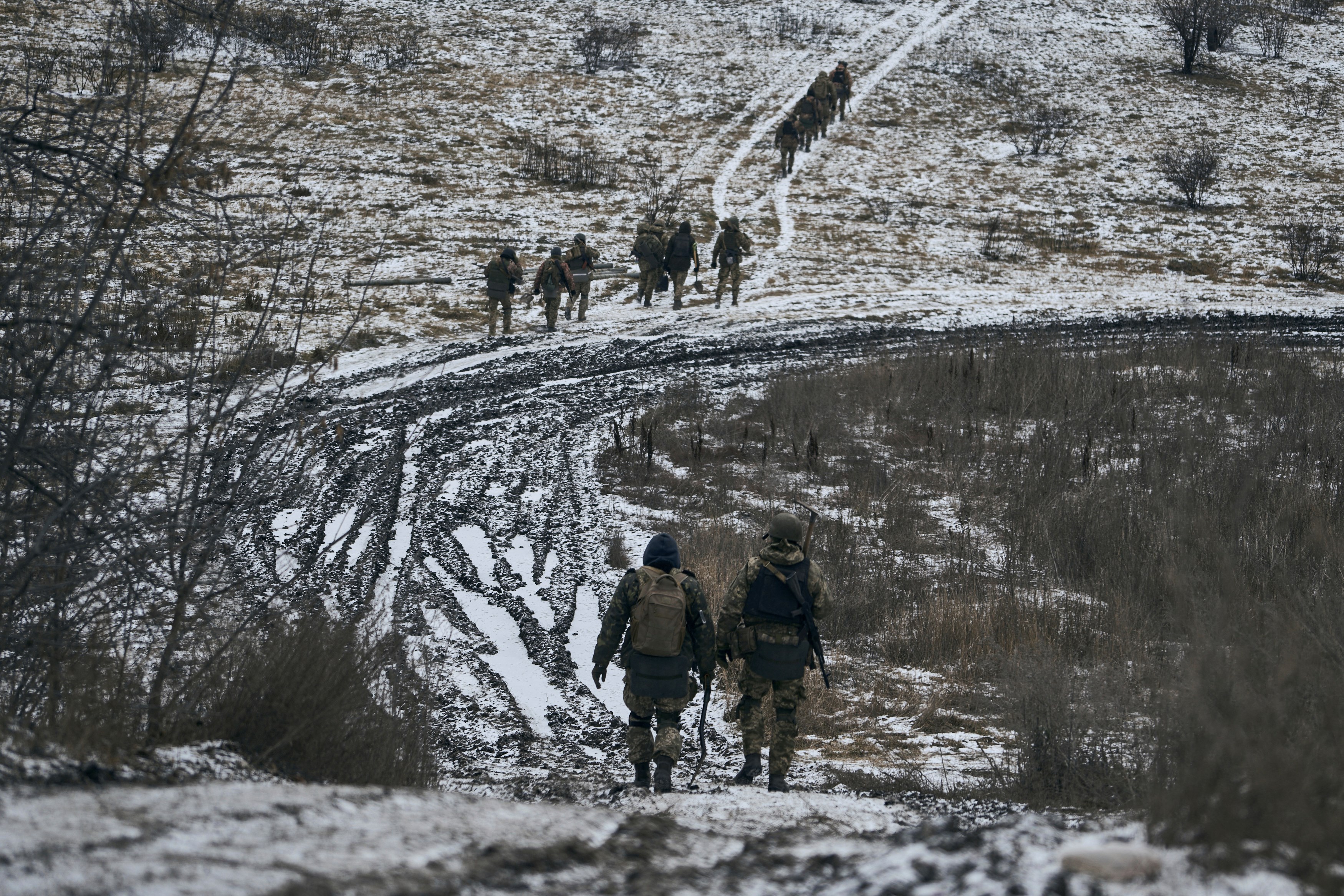 Ukrainian soldiers walk in the position close to Bakhmut, Ukraine, Thursday, Jan. 12, 2023 (AP Photo/LIBKOS)