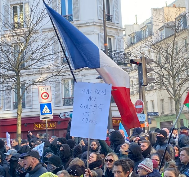 Protestors in France raise a sign in criticism of President Emmanuel Macron's pension reform plan (Social Media)