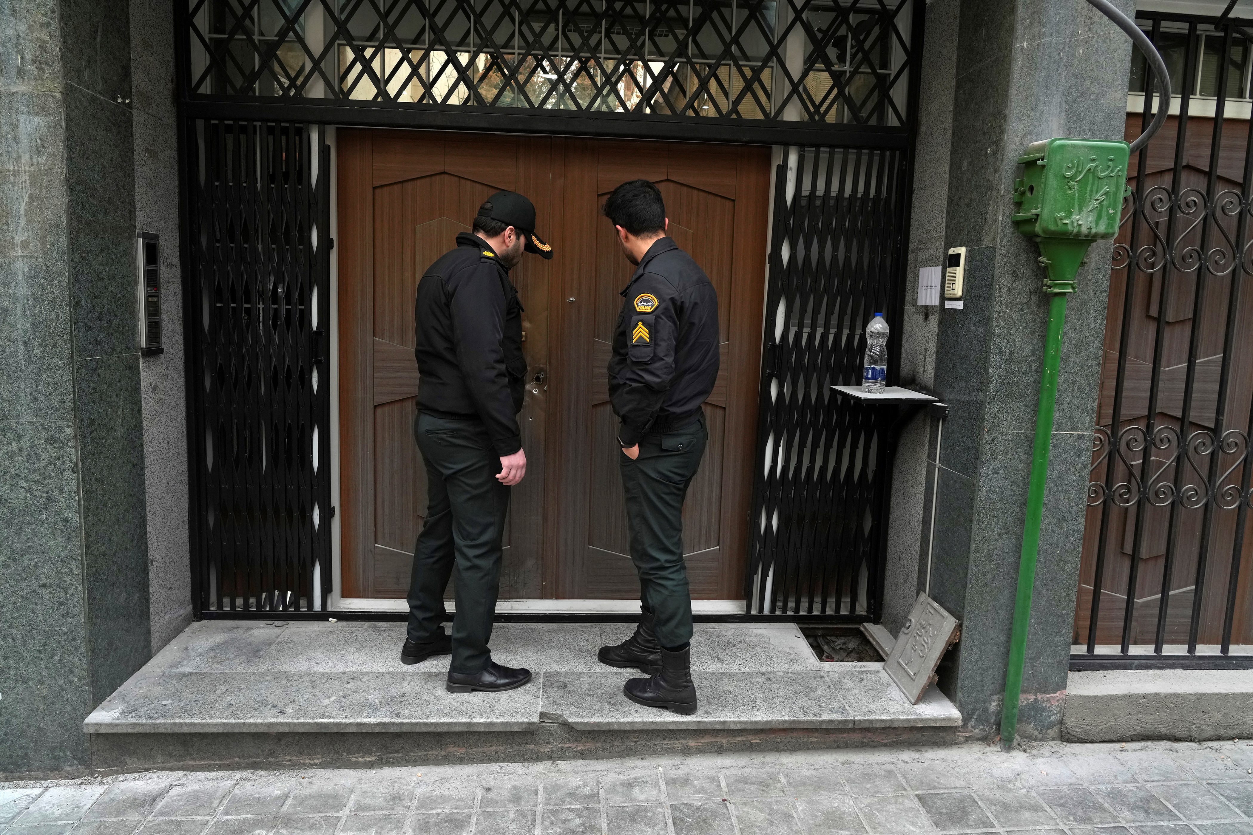 A police officer knocks on the door of the Azerbaijan Embassy in Tehran, Iran, Friday, Jan. 27, 2023 (AP Photo/Vahid Salemi)