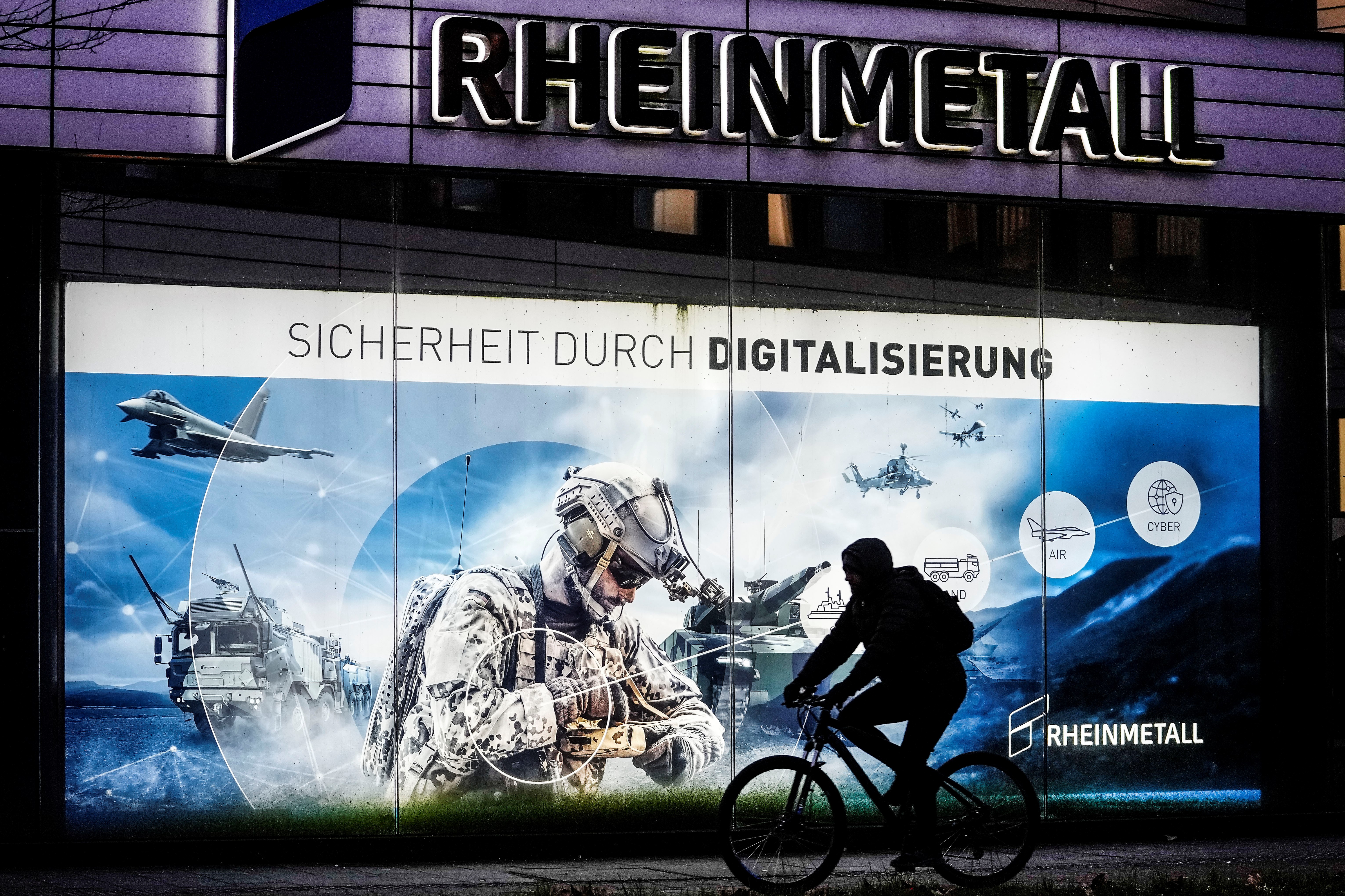 A man on a bicycle passes the headquarters of Germany's biggest arms manufacturer Rheinmetall AG in Duesseldorf, Germany, Monday, Jan. 23, 2023 (AP Photo/Martin Meissner)