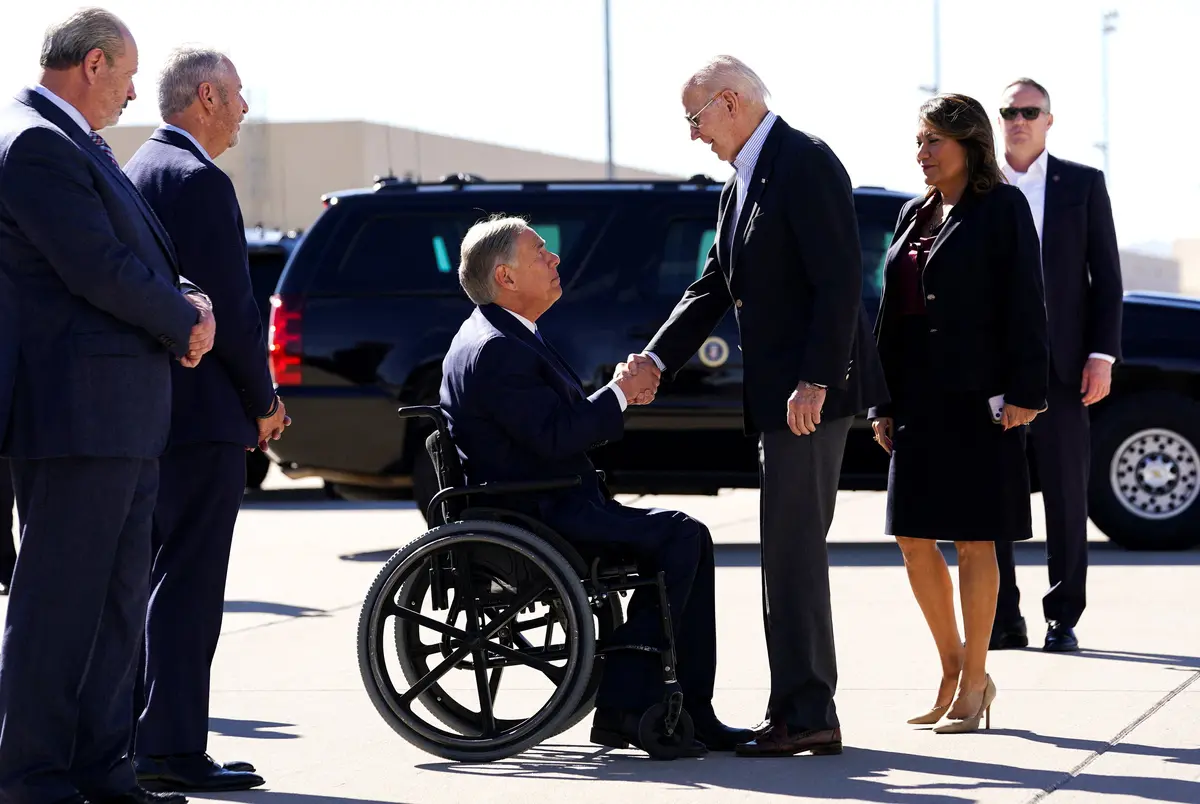 President Joe Biden shakes hands with Texas Governor Greg Abbott upon his arrival in El Paso on Jan. 8, 2023 (Reuters)