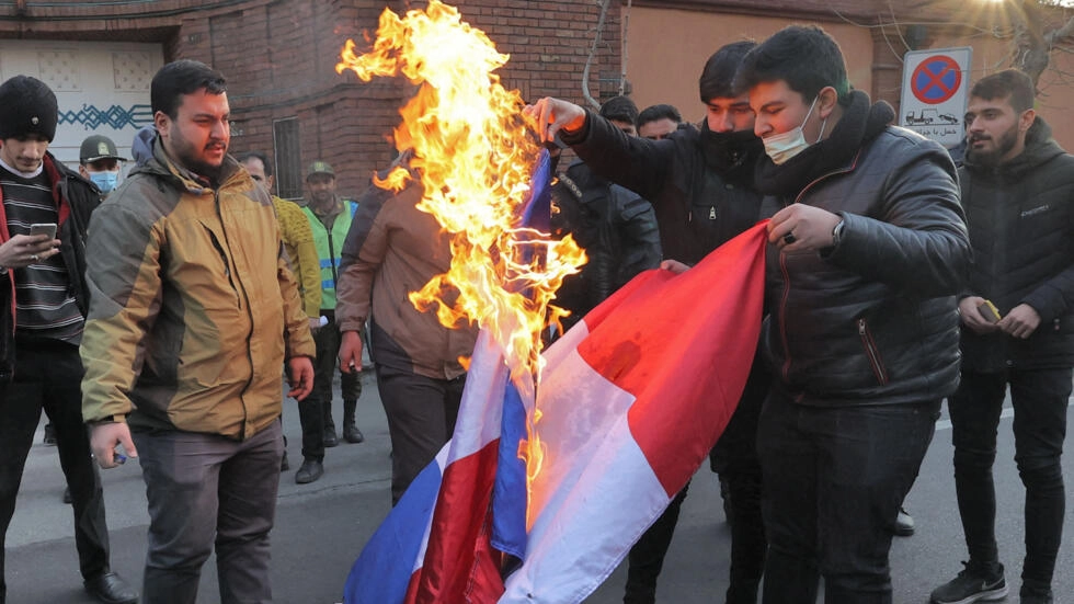 Demonstrators burn a French flag during a protest against Charlie Hebdo, in front of the French embassy in Tehran, Iran, on January 8, 2023 (AFP).