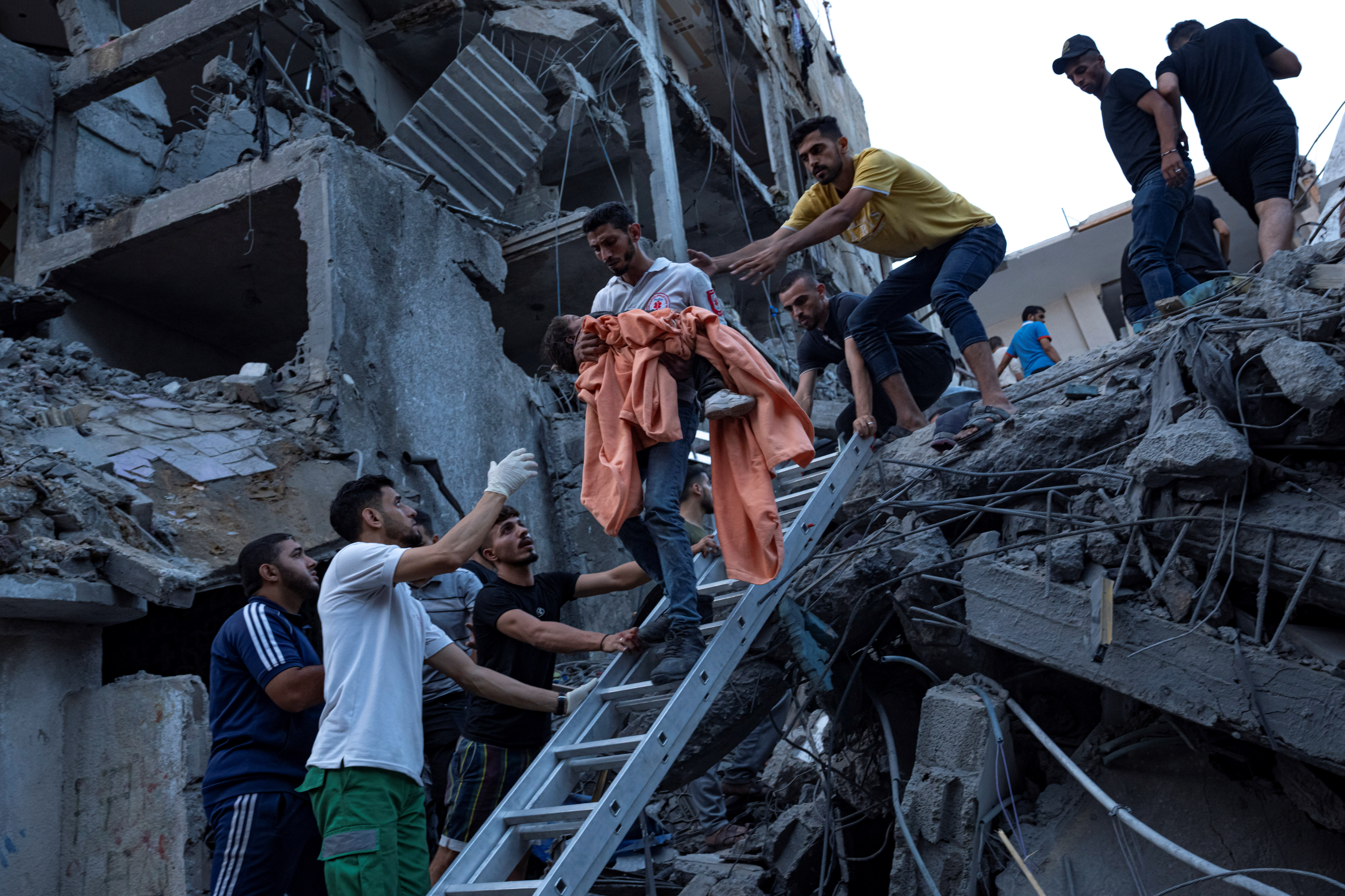 Palestinians rescue a young girl from the rubble of a destroyed residential building following an Israeli airstrike on Gaza, October 10, 2023 (AP)