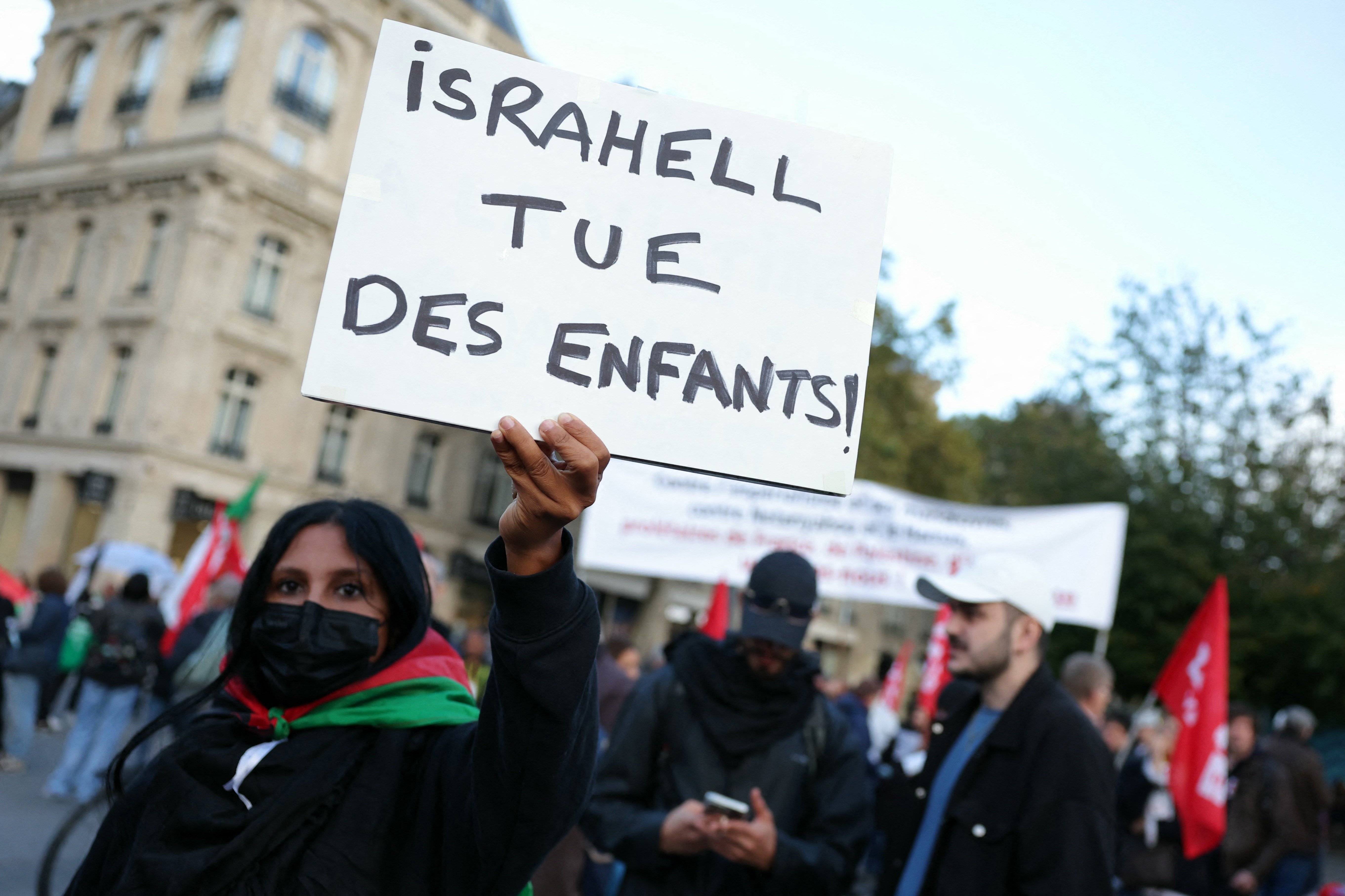 A protestor holds a placard reading