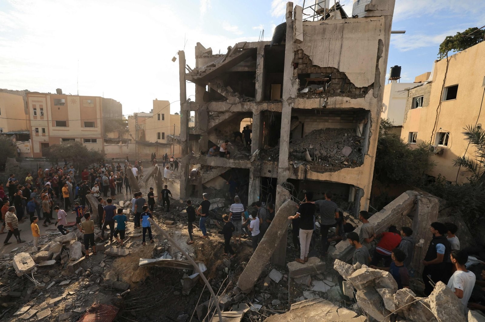 Palestinians search through the rubble of a building after an Israeli strike in Khan Younis in the southern Gaza Strip, Palestine, Oct. 17, 2023. (AFP)