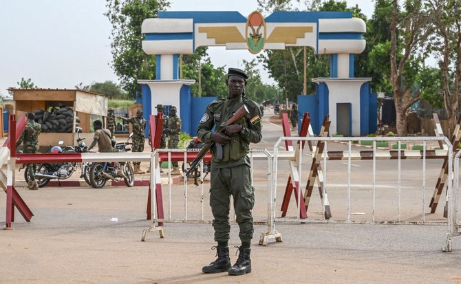 A Nigerien National Police officer stands guard as supporters of Niger's military junta protest outside the Niger and French airbase in Niamey on August 30, 2023 (AFP)