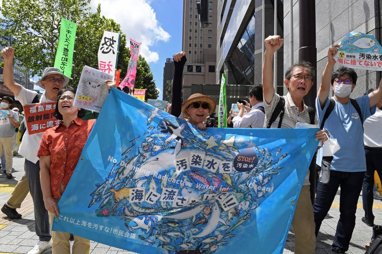 Protesters hold a banner which reads