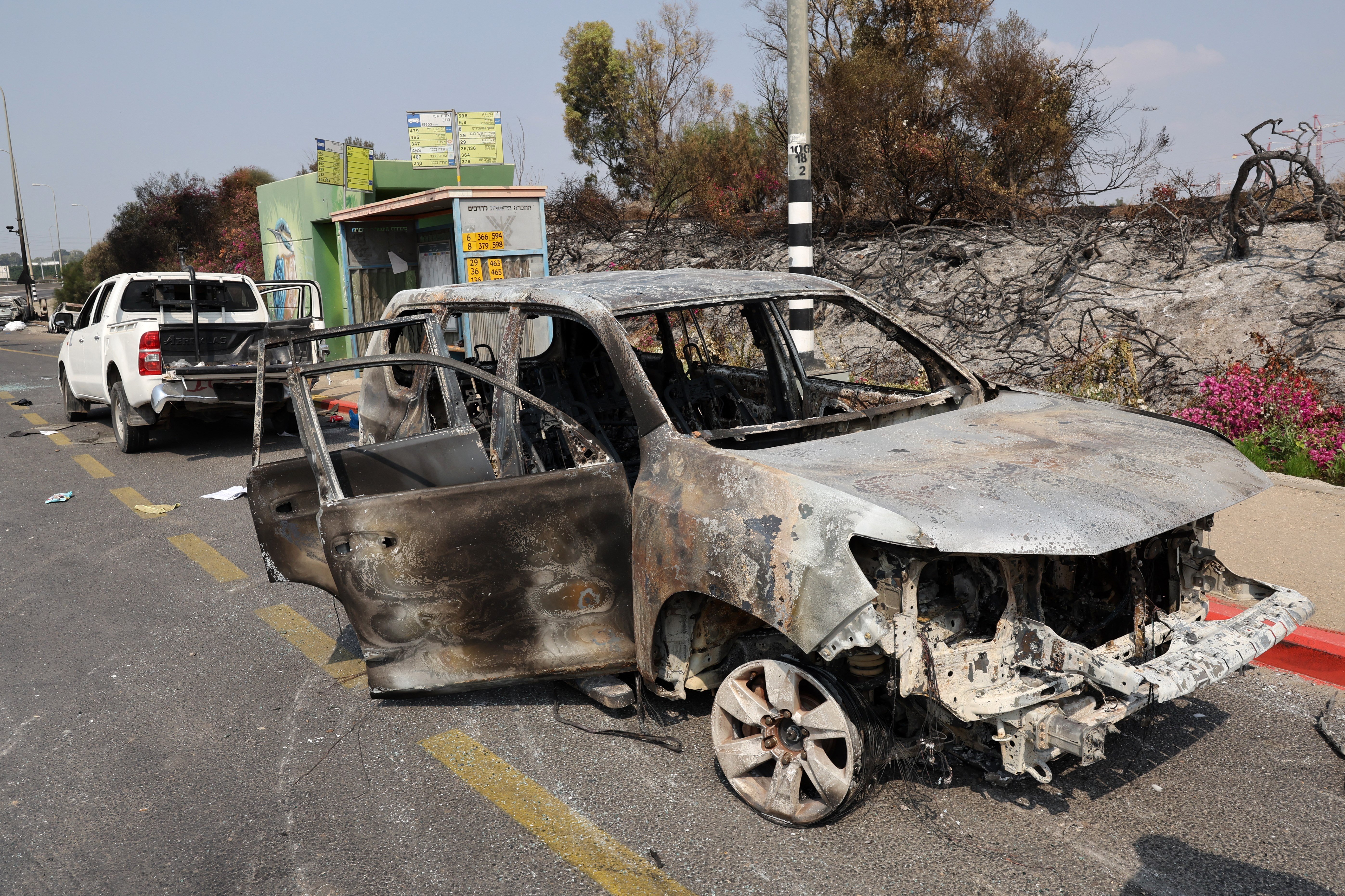 Cars burned during an infiltration by Palestinian militants from the Gaza Strip, sit on the side of a road a day after the attack, near the southern city of Sderot on October 8, 2023