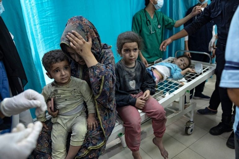 Palestinian mother and her children wounded in Israeli bombardment of the Gaza Strip are brought to a hospital in northern Gaza (AP)