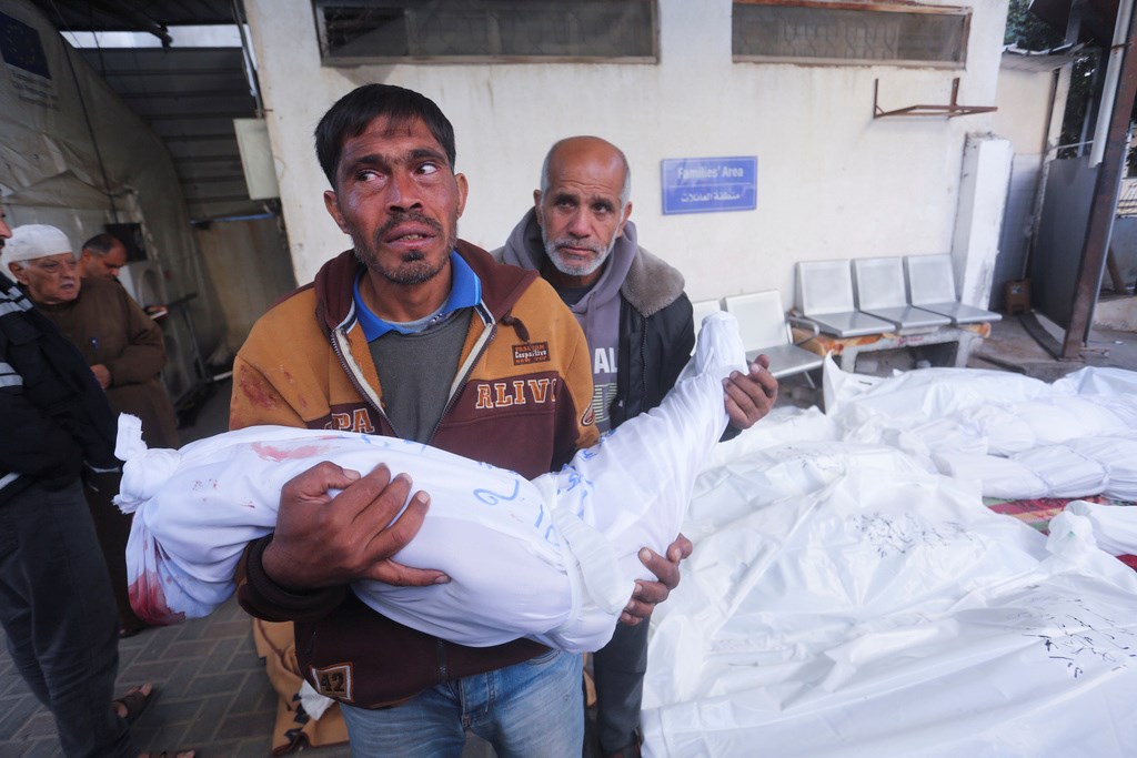 A Palestinian mourns relatives killed in the Israeli bombardment of the Gaza Strip at a morgue in Rafah on Tuesday, Dec. 12, 2023 (AP)