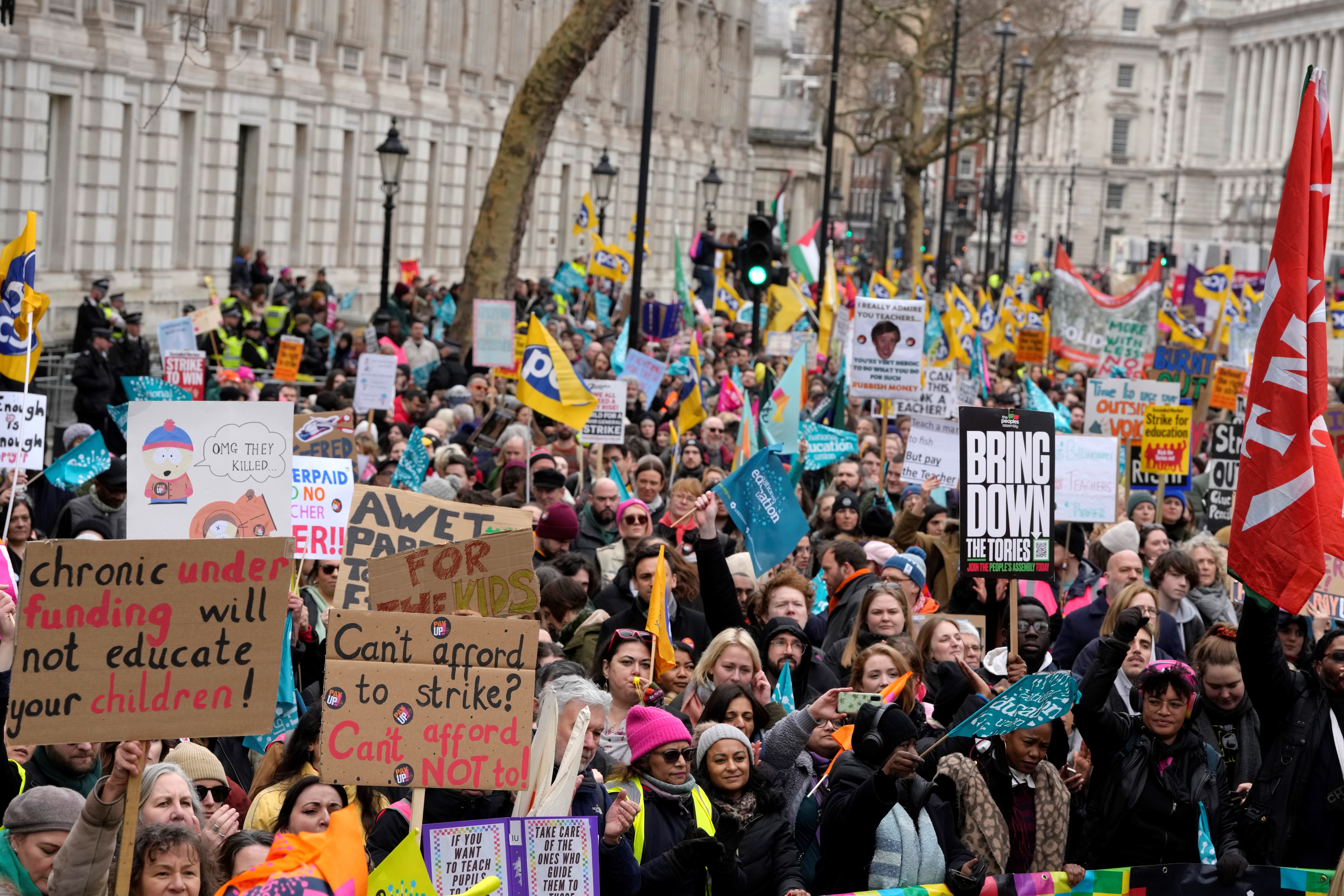 Thousands of demonstrators wave banners as they stand near Downing Street in Westminster in London, Wednesday, Feb. 1, 2023 (AP Photo/Kirsty Wigglesworth)
