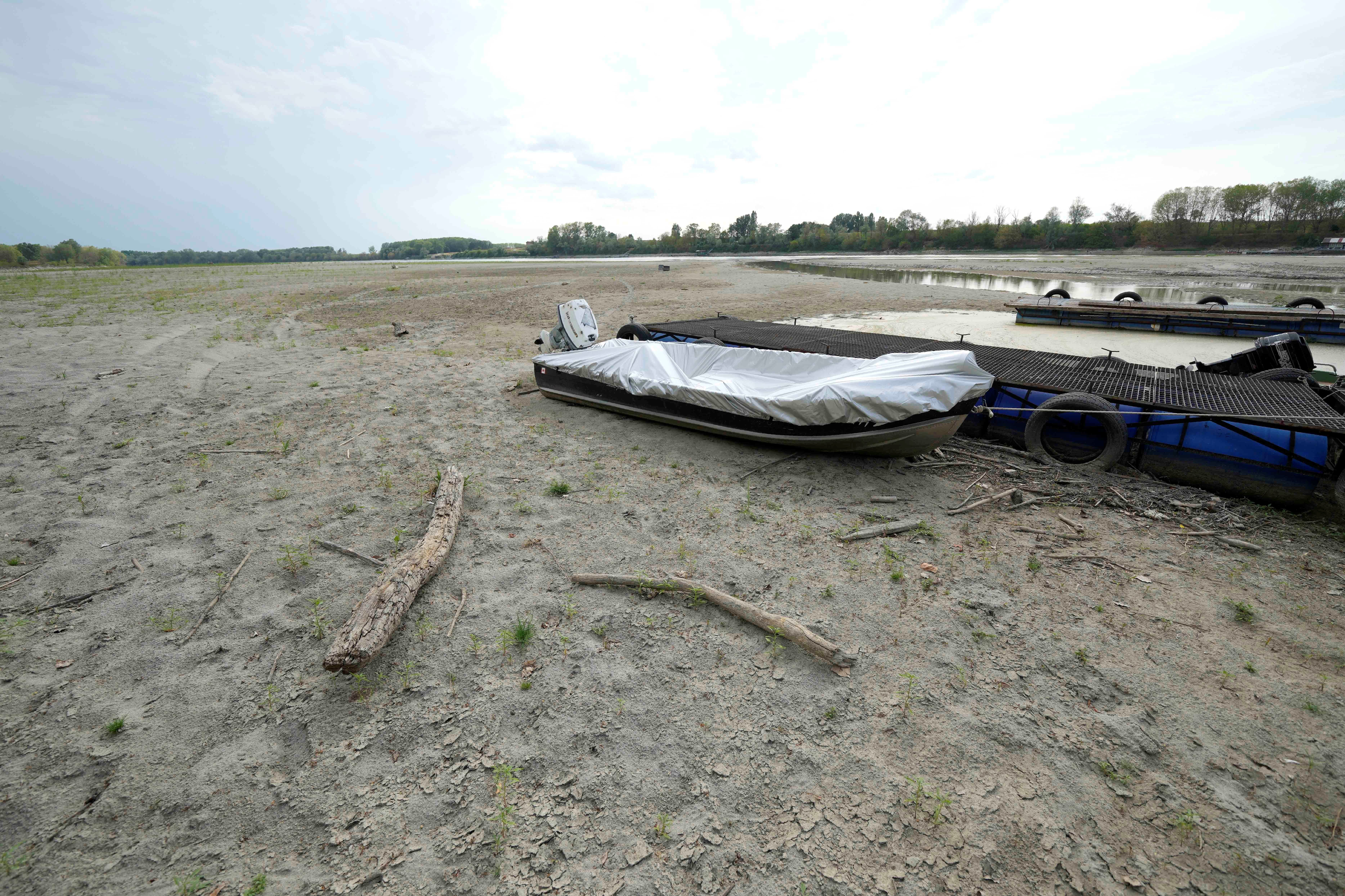 Boats lie on the dried riverbed at a tourist dock along the Po river in Ficarolo, Italy, Thursday, July 28, 2022 (AP).