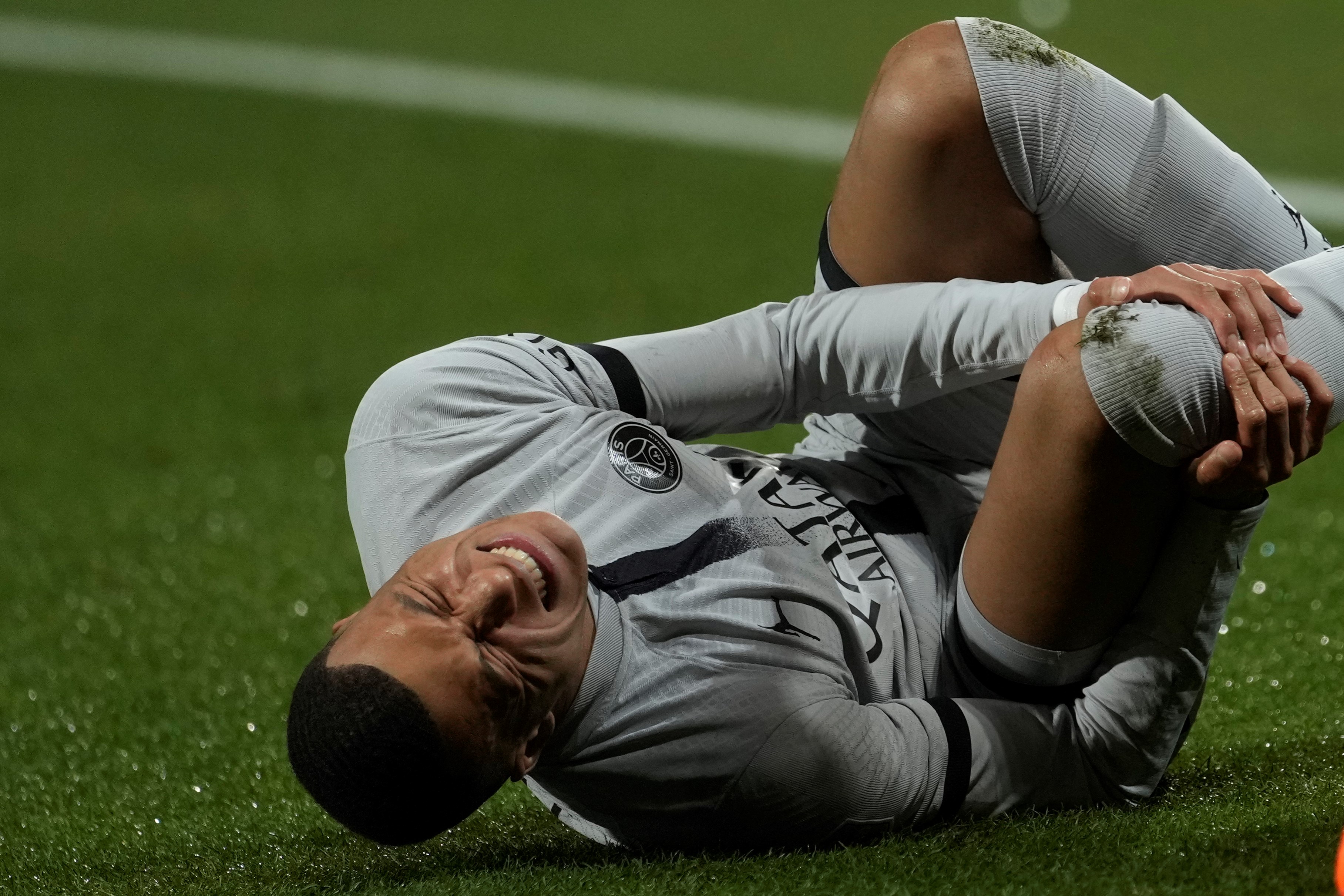 Injured PSG's Kylian Mbappe grimaces in pain during the French League One soccer match between Montpellier and Paris Saint-Germain at the State La Mosson stadium in Montpellier, France, Wednesday, Feb. 1, 2023 (AP Photo/Thibault Camus)