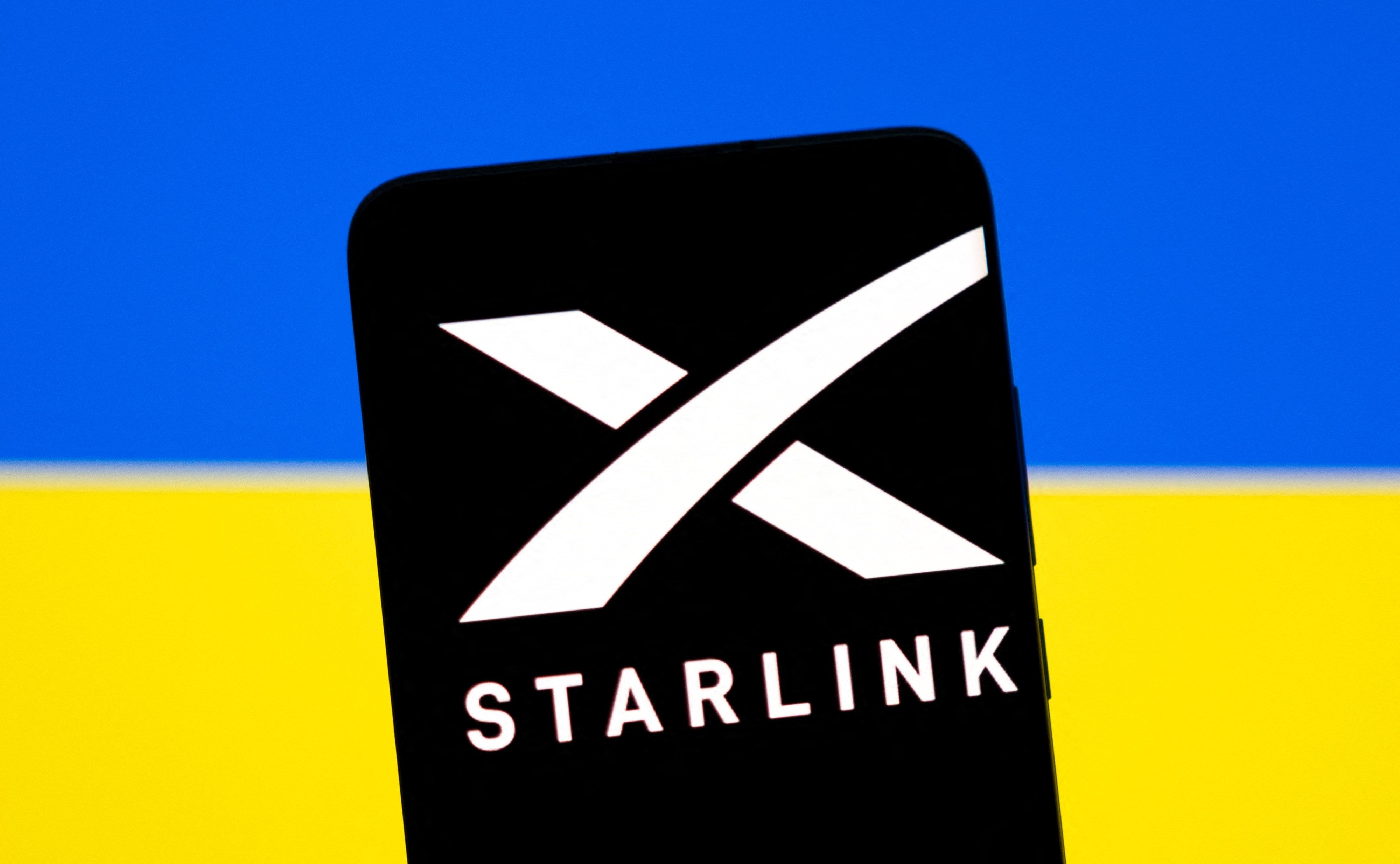 Starlink logo is seen on a smartphone in front of displayed Ukrainian flag in this illustration taken February 27, 2022. (Reuters)