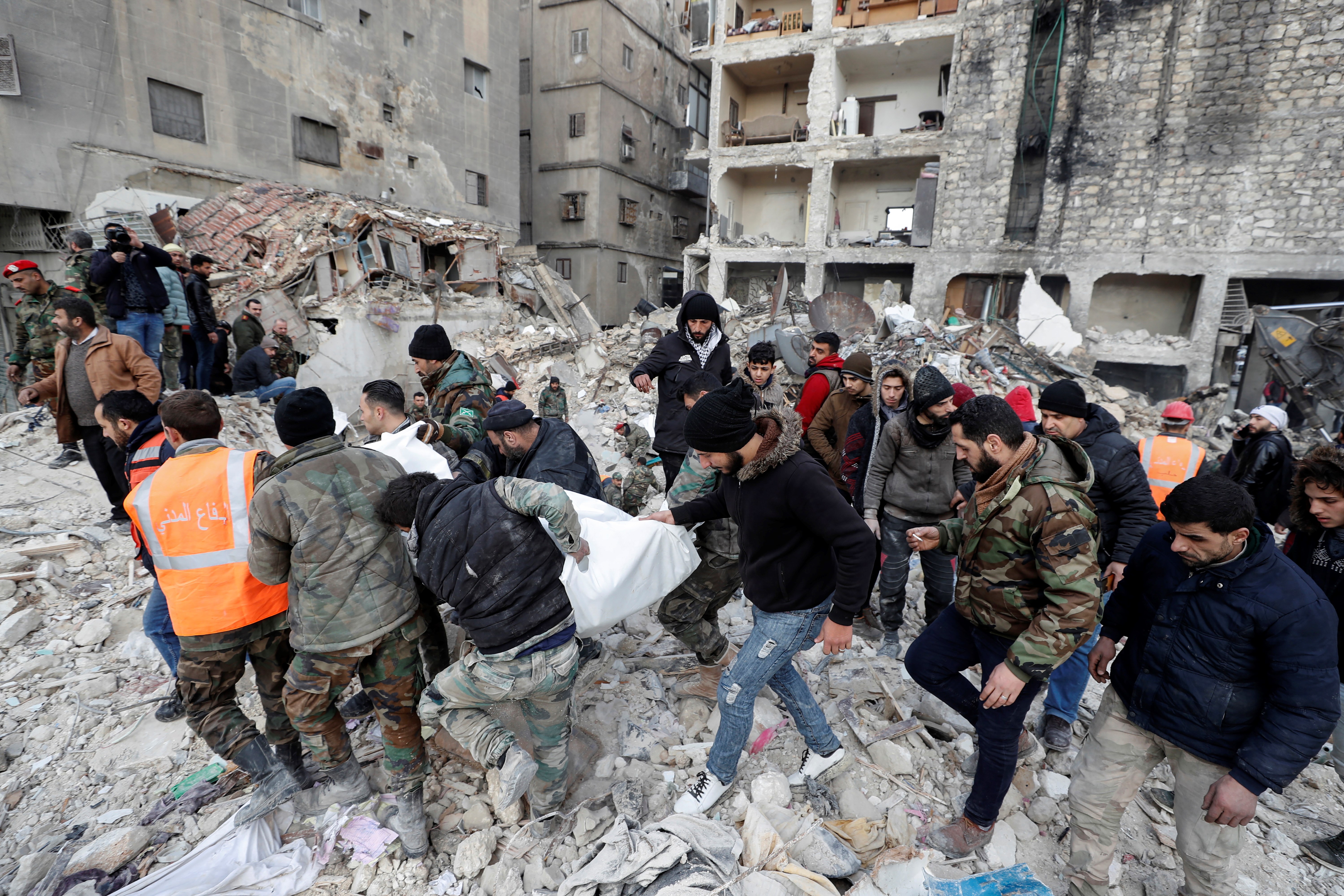 Rescue teams carry the body of a victim from a destroyed building in Aleppo, Syria, Tuesday, Feb. 7, 2023 (AP Photo/Omar Sanadiki)